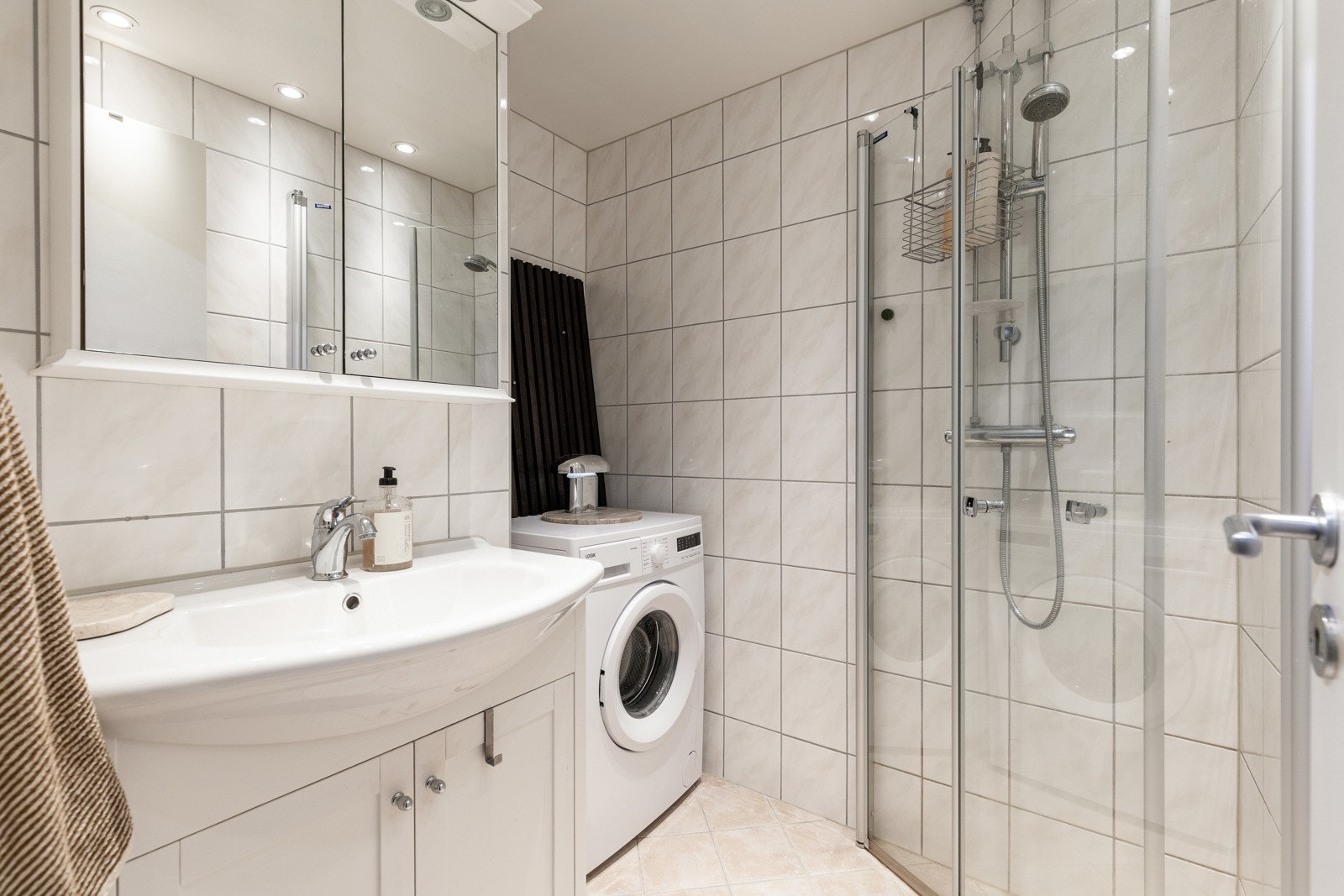 Pent flislagt bad pusset opp av borettslaget i 2016, med praktisk dusjløsning og opplegg for vaskemaskin. Galleribilde