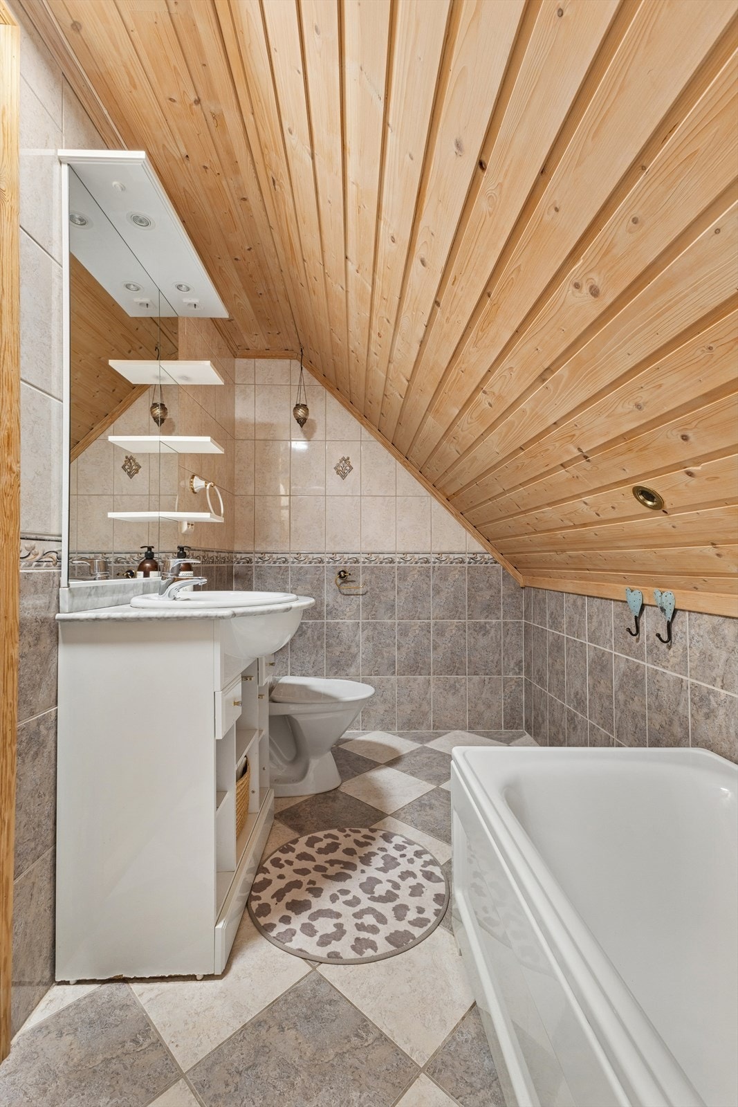 Badet i 2. etasje er fra byggeår og har fliser på gulv og vegger, og panel i himling. Galleribilde