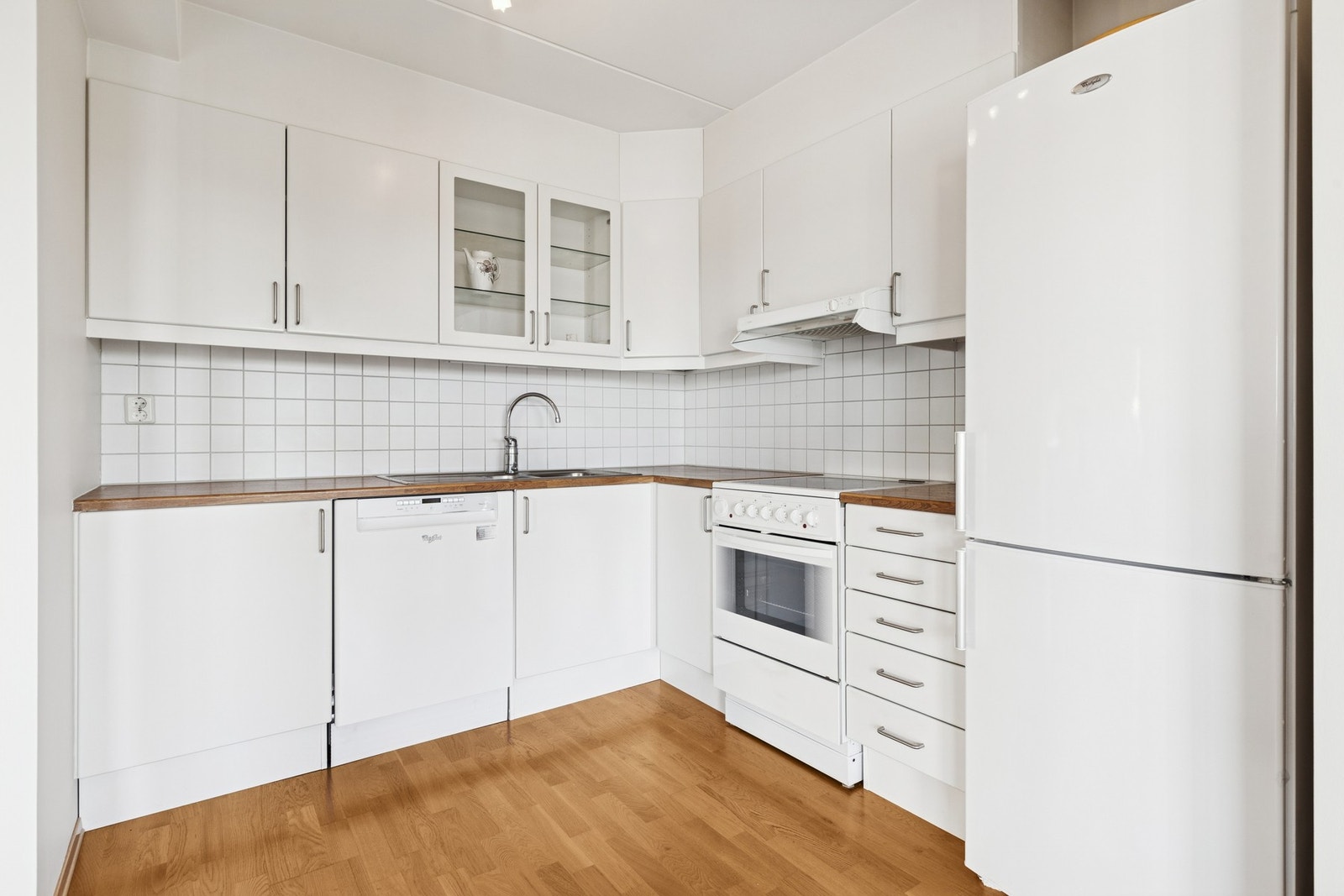 Kjøkkenet har slette fronter, benkeplater av laminat og flislagt veggflate mellom benkeplatene og overskap. Galleribilde