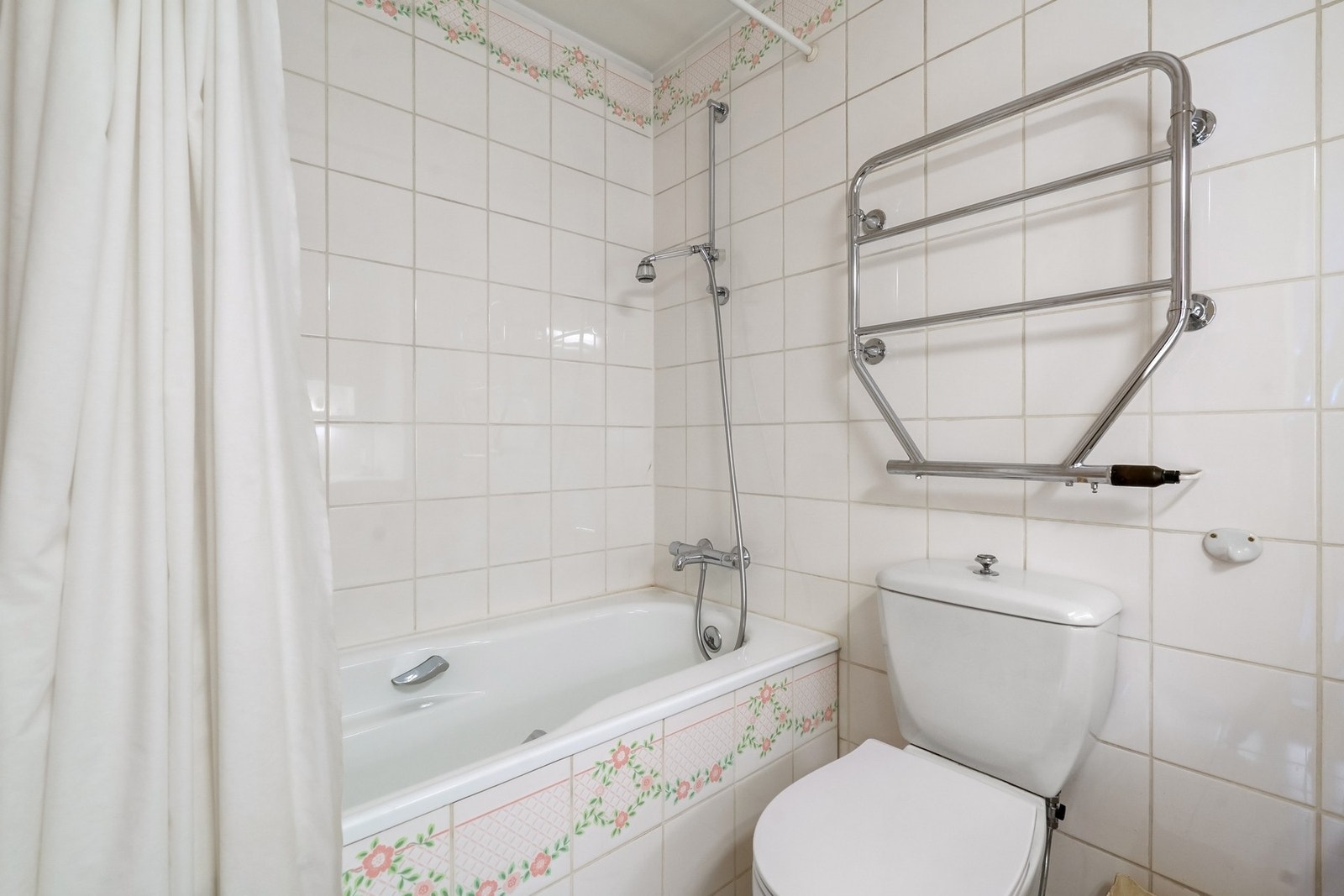 Flislagt baderom med varmekabler fra byggeår med innbygget flislagt badekar, gulvmontert toalett. Galleribilde