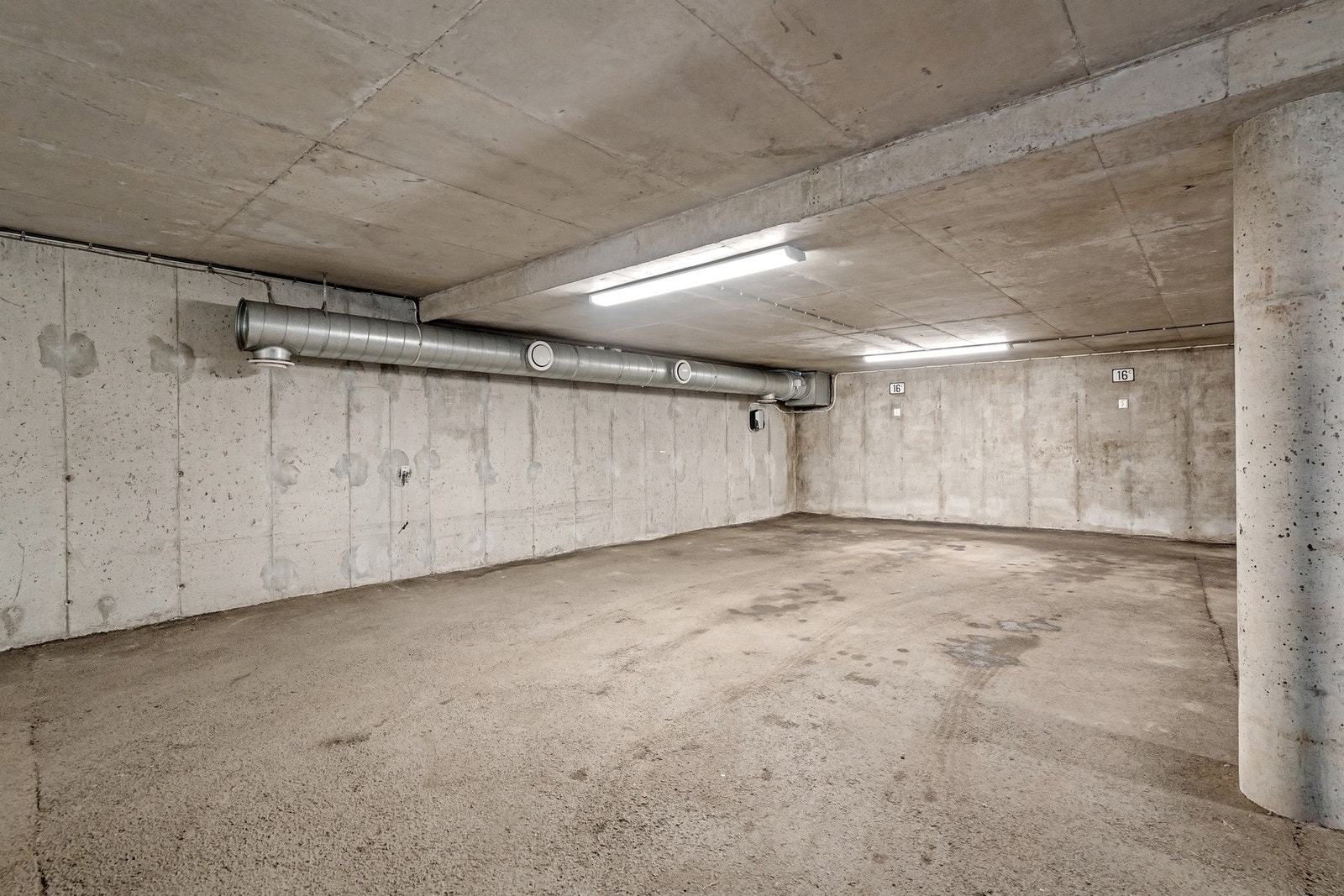To romslige parkeringsplasser i felles underjordisk garasjeanlegg med direkte adkomst til boligen via en mellomgang. Kun den ene plassen har elbillader. Galleribilde