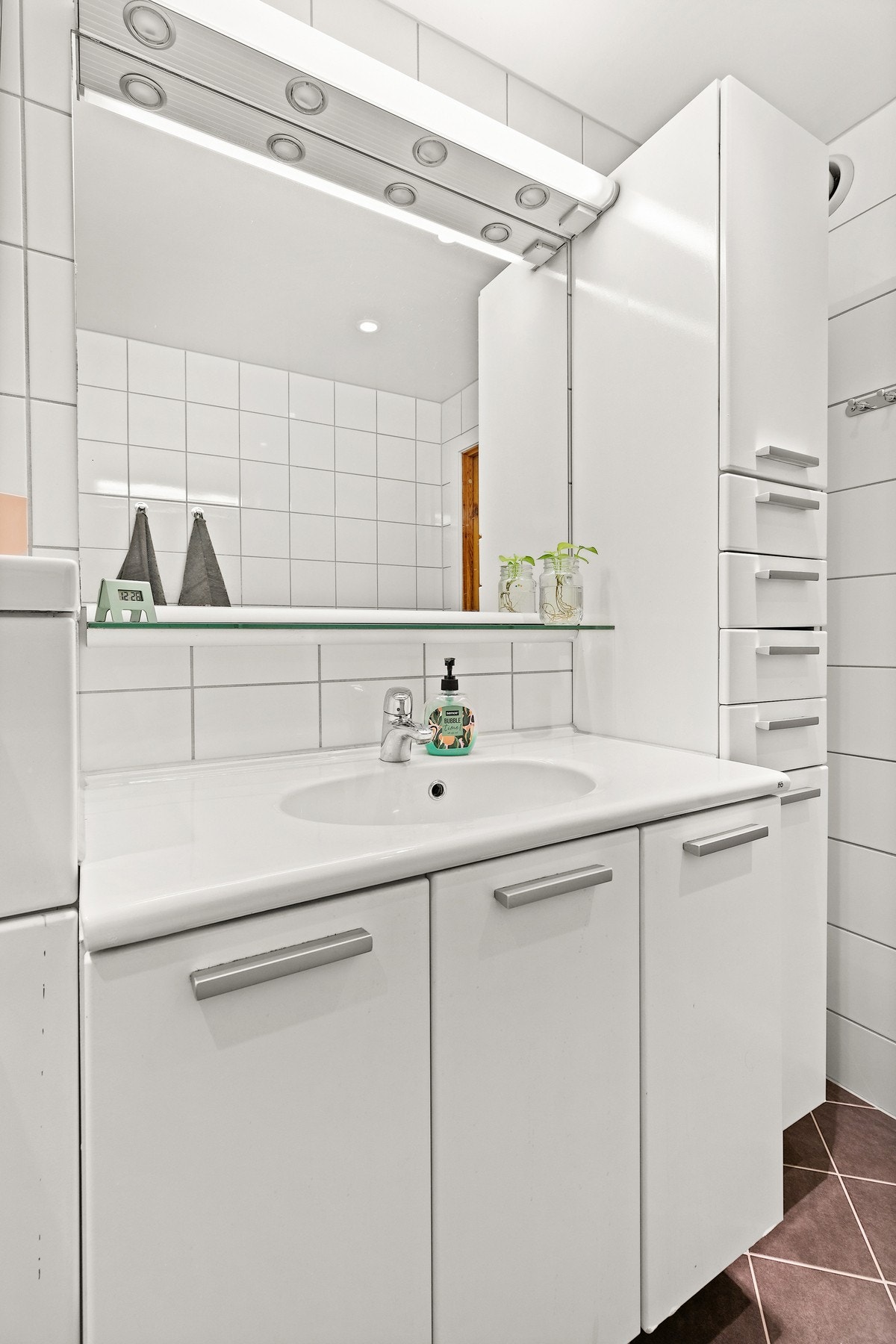 Videre er badet også innredet med speil m/lys, servant- og høyskap for oppbevaring av toalettsaker Galleribilde