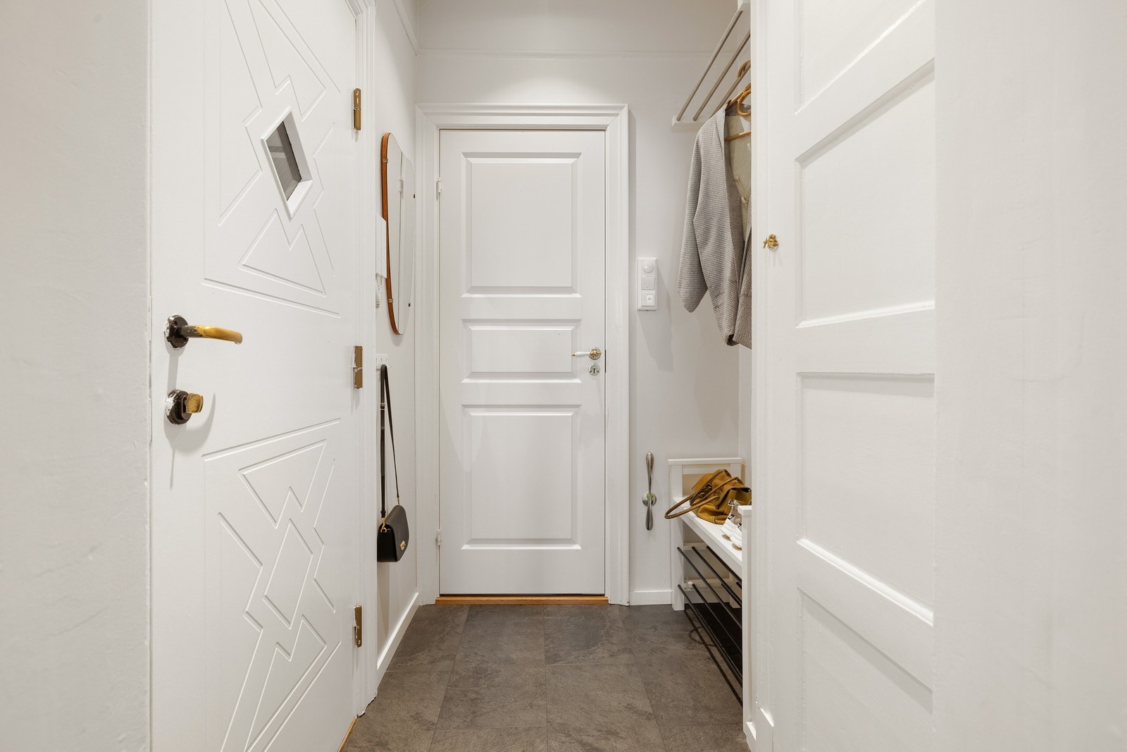Velkommen inn! Leiligheten ønsker velkommen med en lys og funksjonell entré. Her er det plass til yttertøy og sko, og overflatene består av laminat på gulv, slette malte vegger og himling. Galleribilde