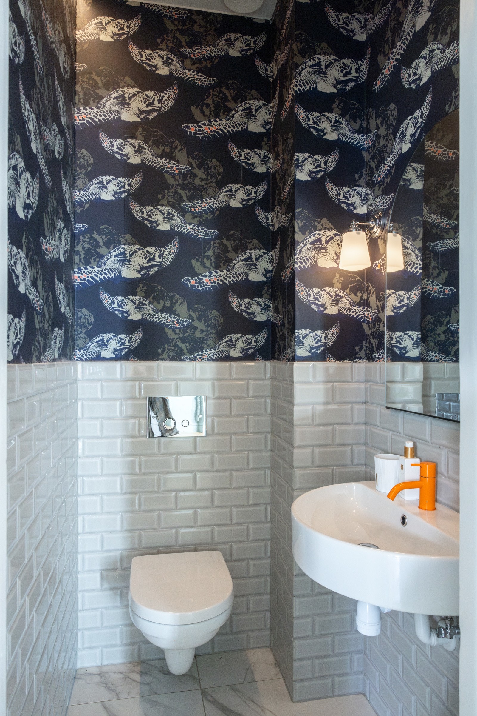 Toalettrommet i hovedetasjen er delvis flislagt og tapetsert, og har et moderne uttrykk. Det er påkostet tapet fra Colefax og Jane Churchill på veggene i flere rom