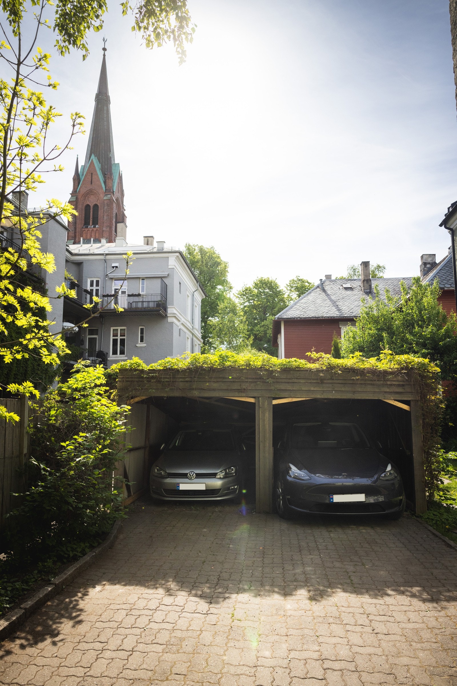 I bakgården er det en dobbel åpen garasje som leiligheten har vedtektsfestet bruksrett til