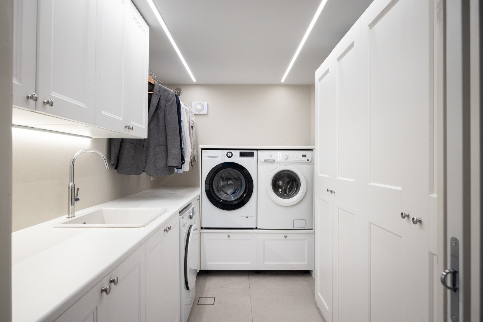 Vaskerommet ligger i underetasjen og er romslig og funksjonelt, med god lagringsplass, utslagsvask og opplegg for to vaskemaskiner og en tørketrommel under benk