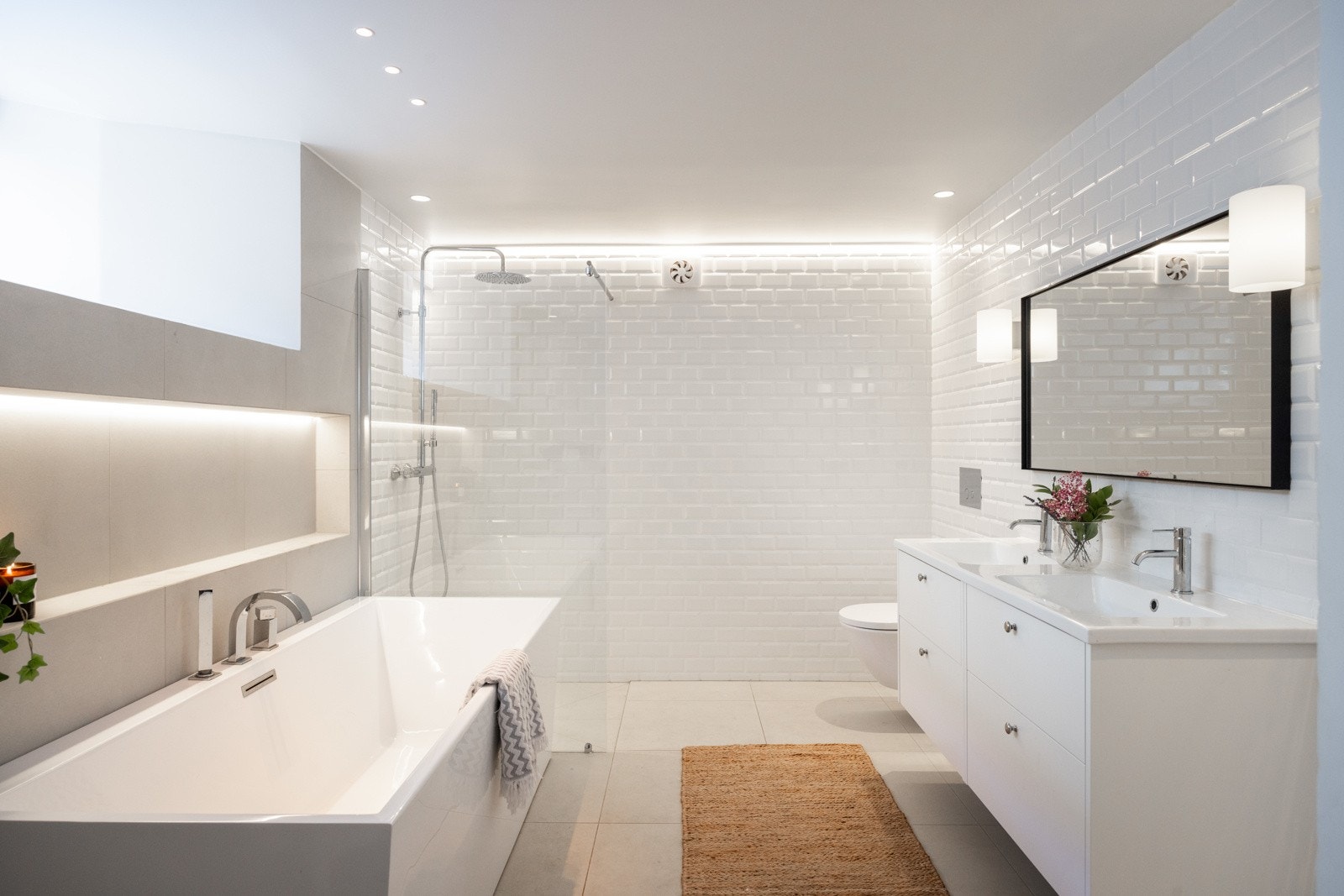 Bad II, som ligger i underetasjen, er et stort og funksjonelt familiebad. Det har en egen dusjnisje med regnfalls- og håndholdt dusj og armaturer fra Tapwell. I tillegg har badet et badekar - perfekt for litt ekstra hverdagsluksus, og supert for barna