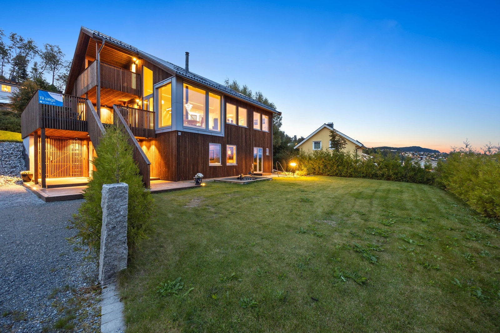 Pent opparbeidet uteområde med bed, busker og plattinger/terrasser. Galleribilde