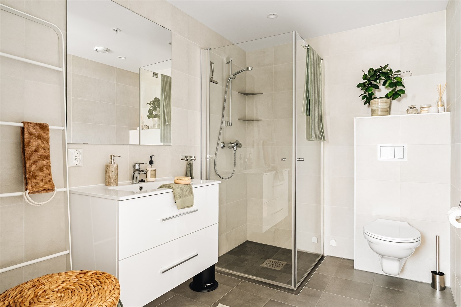 Badet er moderne utformet med fliser på både gulv og vegger, innfelte downlights og gulvvarme som gir ekstra komfort. Her får du en funksjonell hverdagsluksus med det lille ekstra. Galleribilde