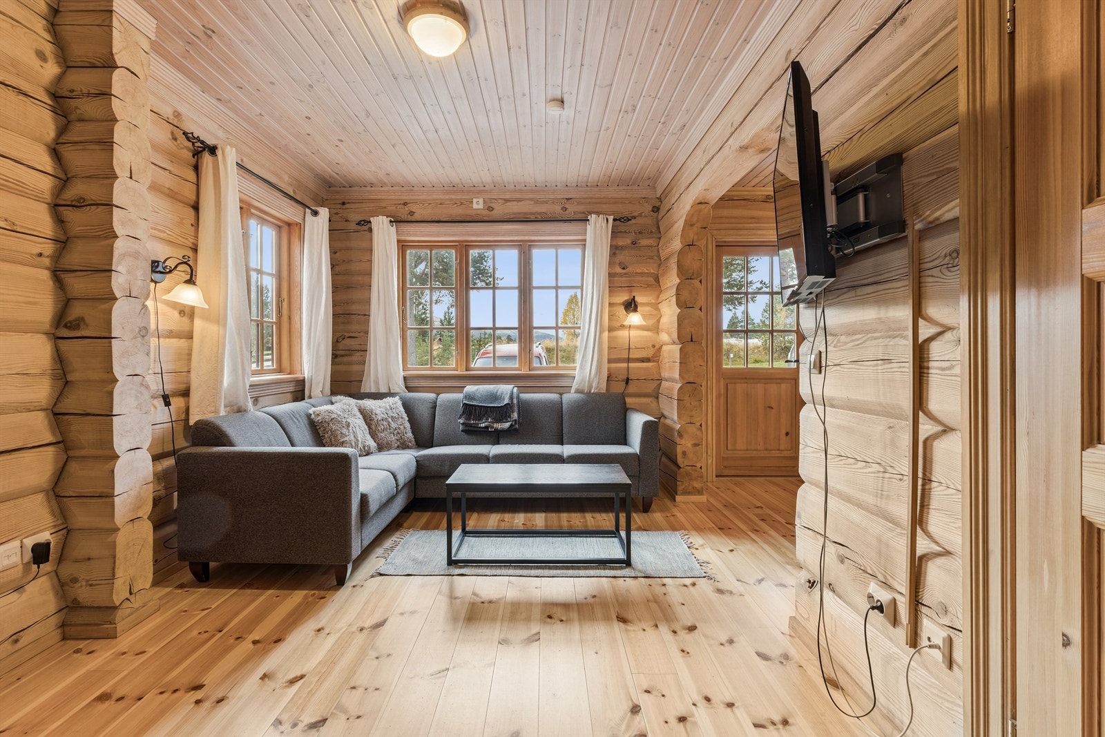 Leiligheten har en åpen og sosial stue med gjennomgående tømmervegger og furugulv. Galleribilde