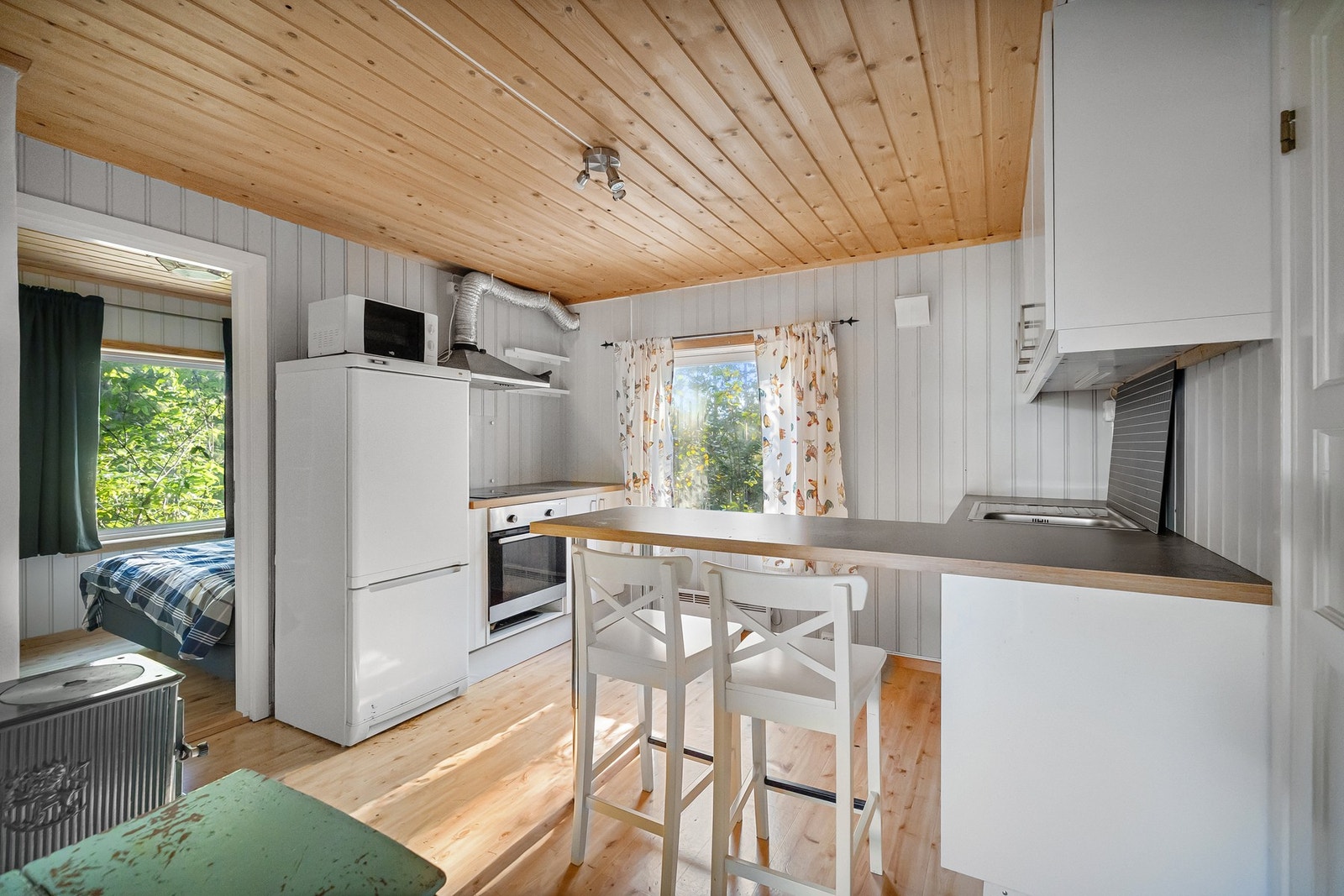 Stilrent kjøkken med hvite fronter og godt med benkeplass. Galleribilde