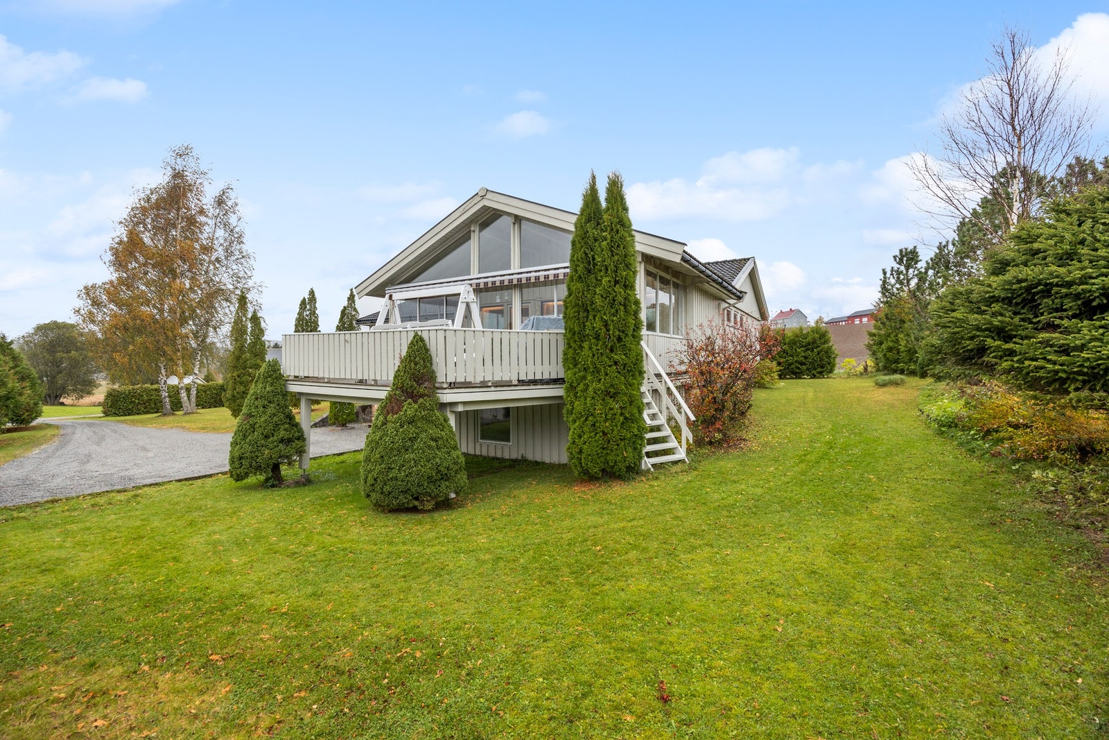 Tomten er pent opparbeidet med plen, busker og trær Galleribilde