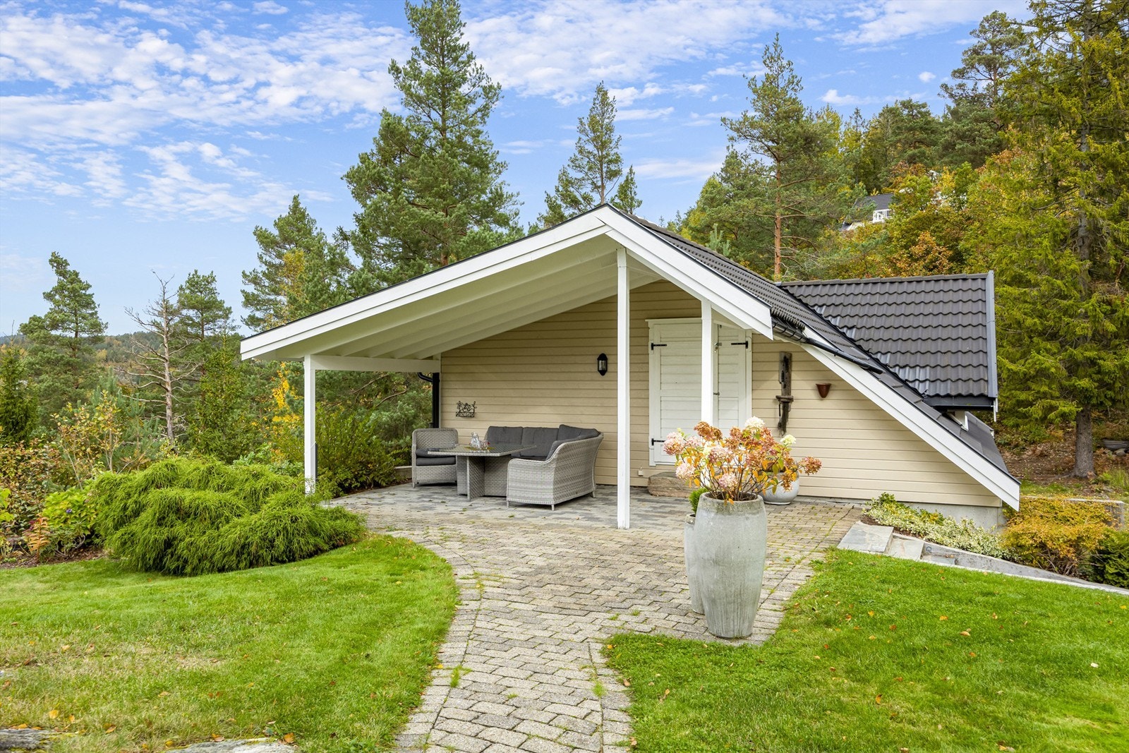 Overbygd terrasseområde. De mange "sonene" på tomten gir passende uteareal til ethvert vær og ønske- enten man vil nyte et lunt måltid i skyggen, leke i hagen eller slappe av i solen på verandaen! Galleribilde