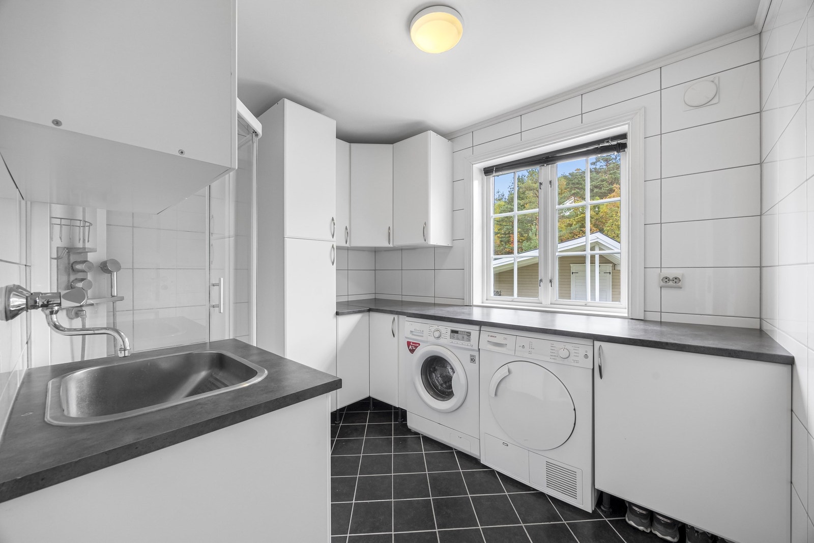 Vaskerom med praktisk innredning, vask og dusj. Flislagt med varmekabler i gulv fra 2010. Galleribilde