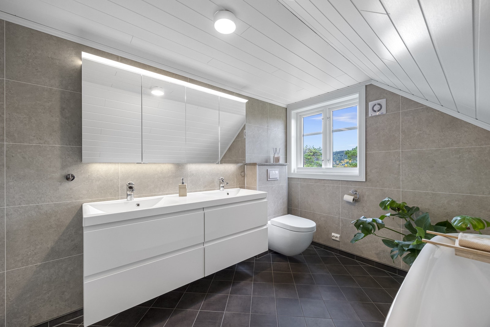 Renovert baderom i 2 etasje utstyrt med badekar, dobbel servantinnredning og vegghengt toalett. 2020. Galleribilde