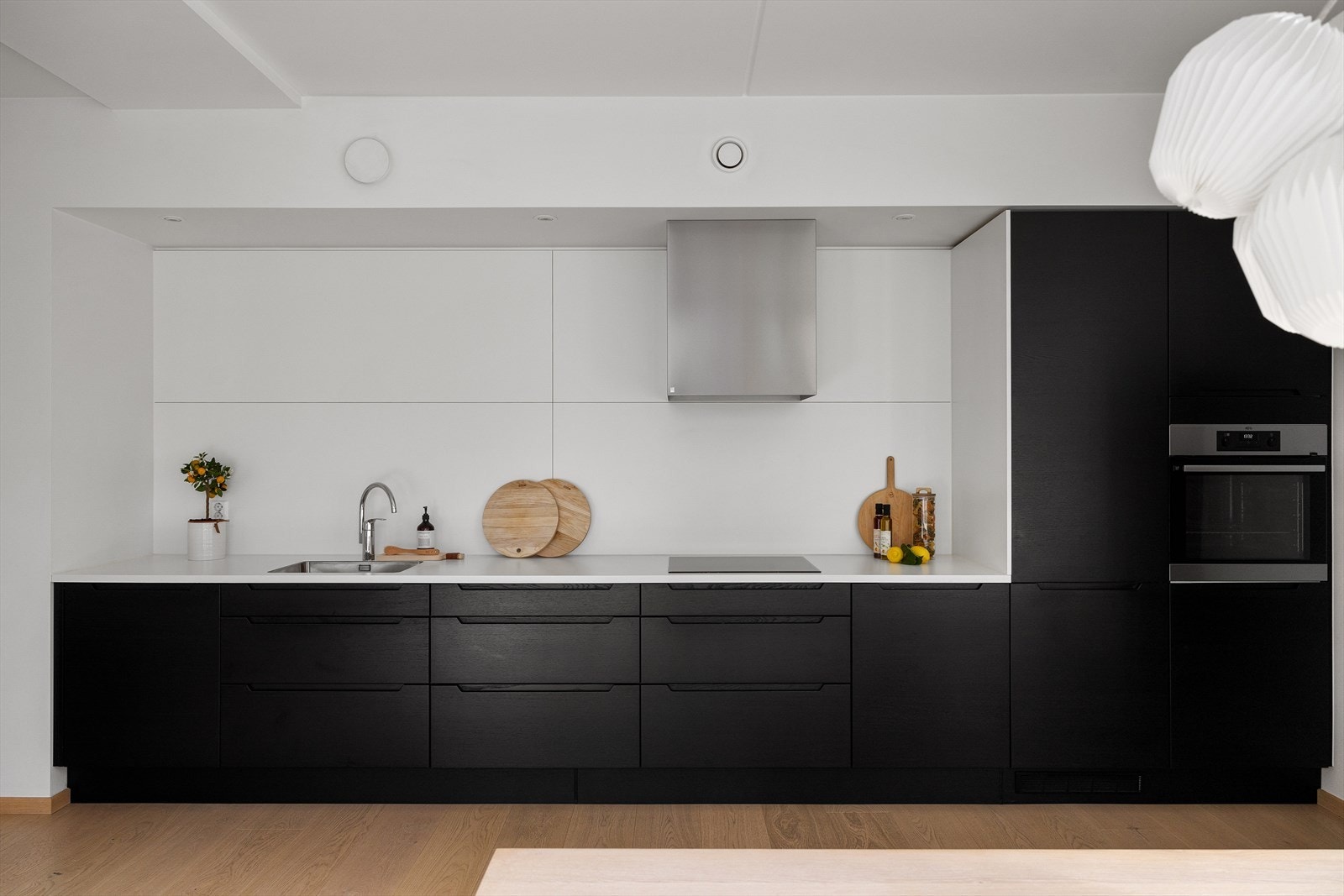 Her er alle hvitevarer integrerte, herunder kjøleskap med fryser, komfyr, induksjonstopp, og oppvaskmaskin. Det er downlights med dimmer over kjøkkenbenken. Galleribilde