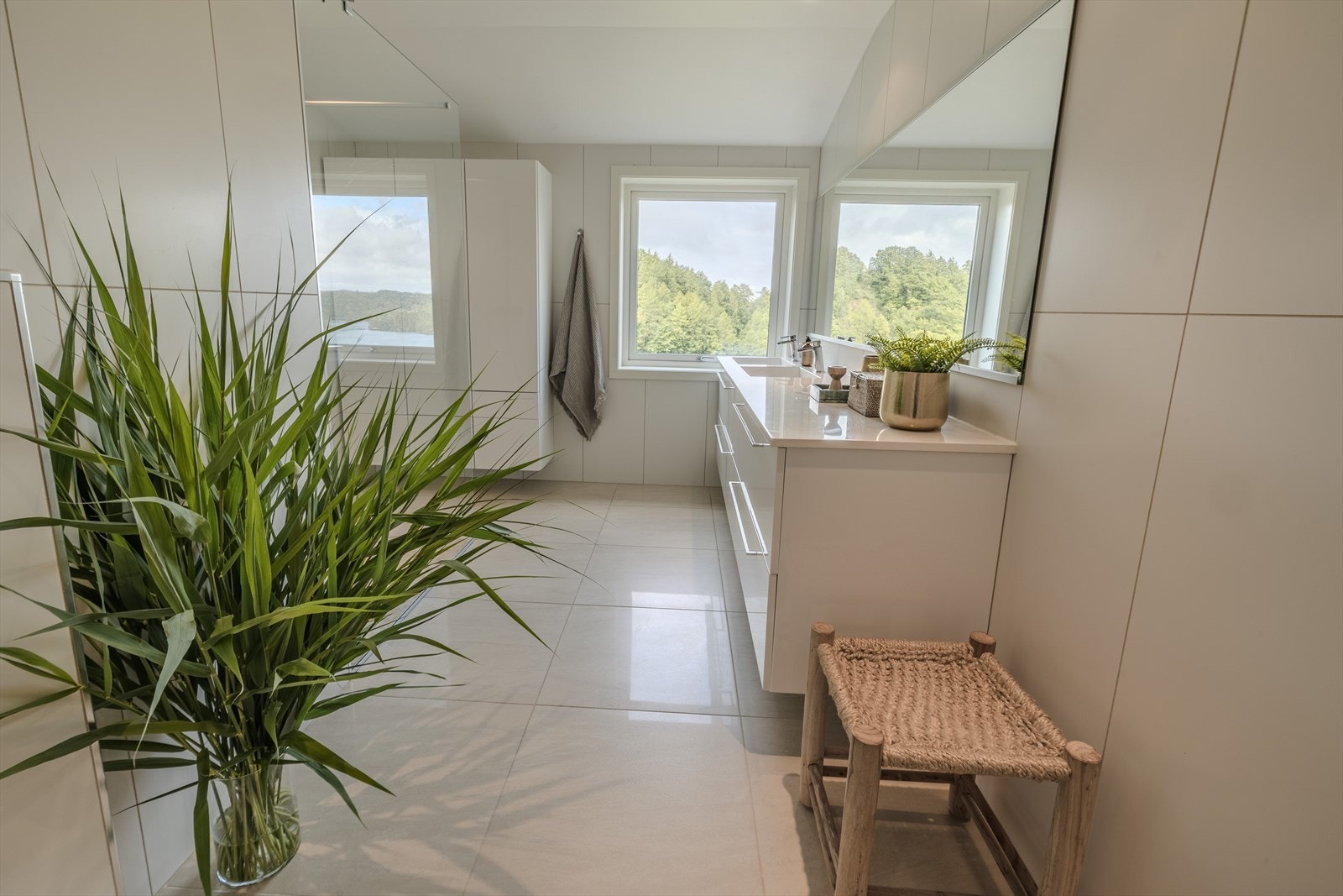 Badet er innredet med dusjhjørne, dobbel vask med innredning, badekar og vegghengt toalett. Galleribilde