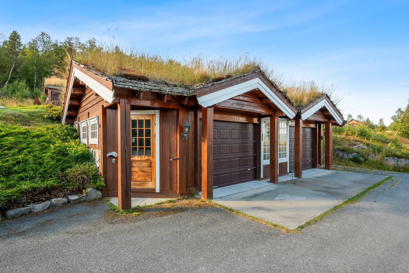 Garasjen er oppført i samme stil som hyttene, utstyrt med gulvvarme, vannuttak og elektriske porter. Galleribilde