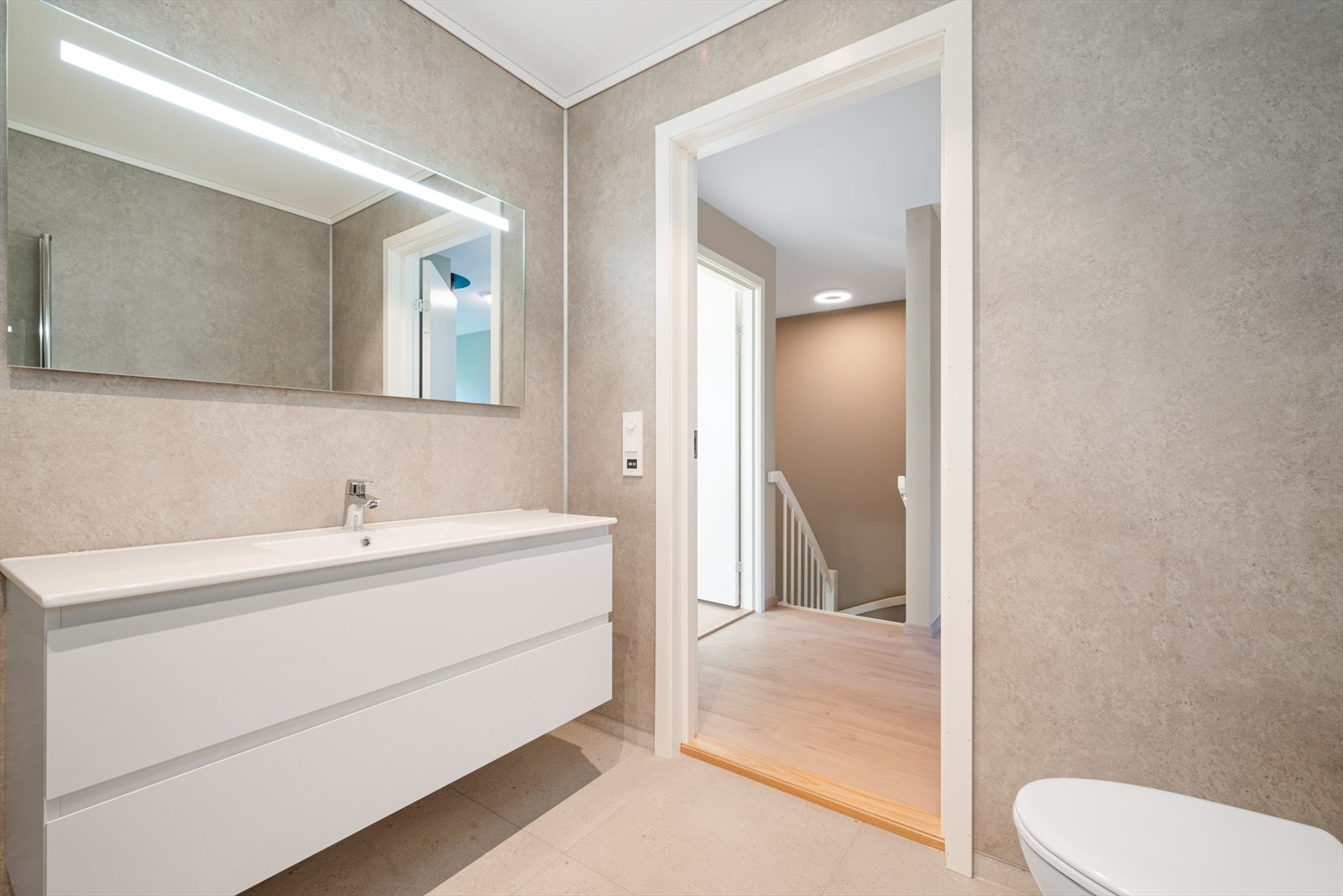 Badet har flislagt gulv med varmekabler og våtromsplater på vegger. Galleribilde