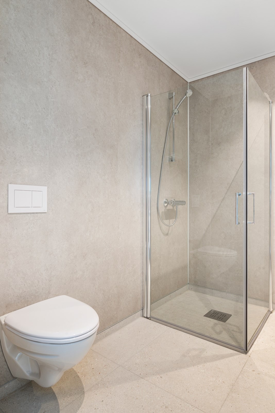 Utstyrt med servantskap, innfellbare dusjdører og vegghengt WC. Galleribilde