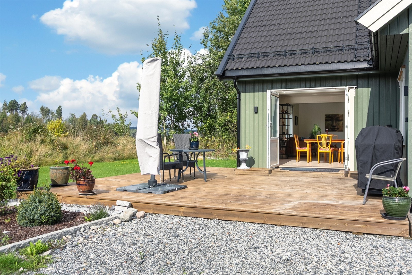 Uteområdet er pent opparbeidet med terrasse, gressplen, diverse beplantning og gruset gårdsplass Galleribilde