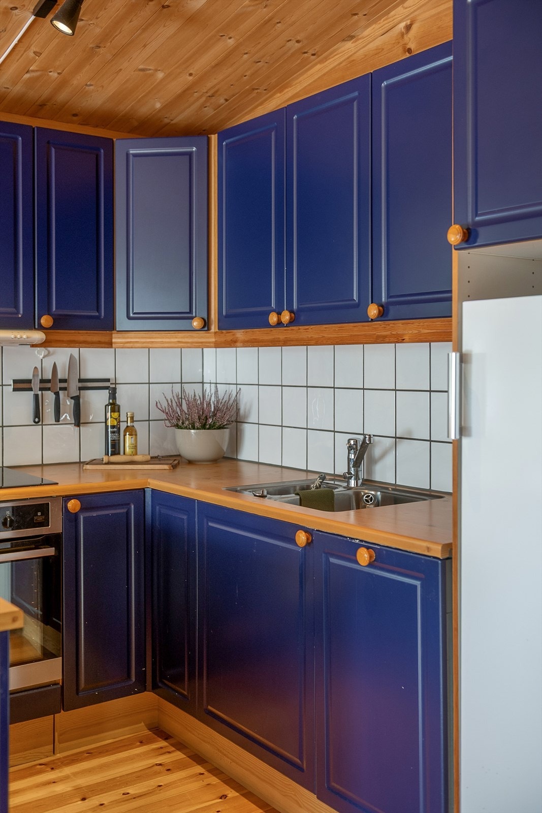 Over-og underslag for oppbevaring. Integrert komfyr og oppvaskmaskin. Plass til kjøleskap. Fliser over benk. Galleribilde