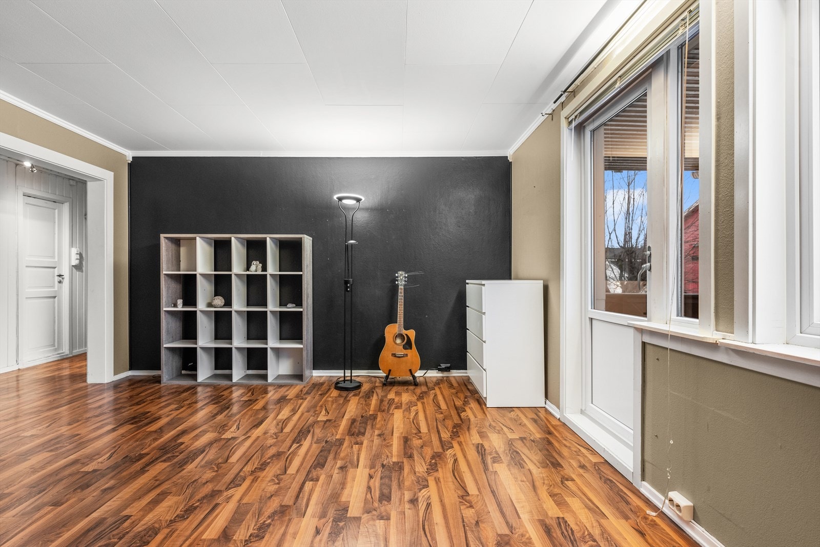 Her er det også plass til spisestue eller noen godstoler. Utgang til en overbygget sørvendt terrasse med nedgang til hage Galleribilde