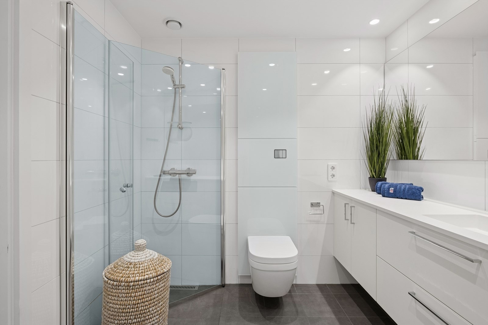 Baderommet er lyst og moderne med fliser på gulv og vegger, og malt overflate i himling. Galleribilde