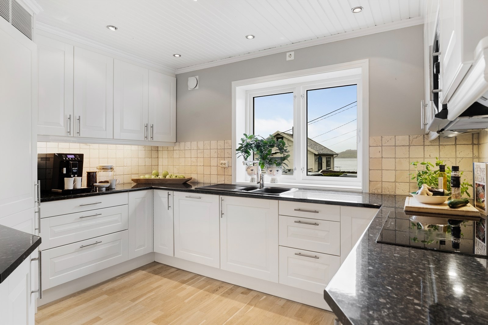 Lyst, innbydende kjøkken med gode arbeidsflater Galleribilde