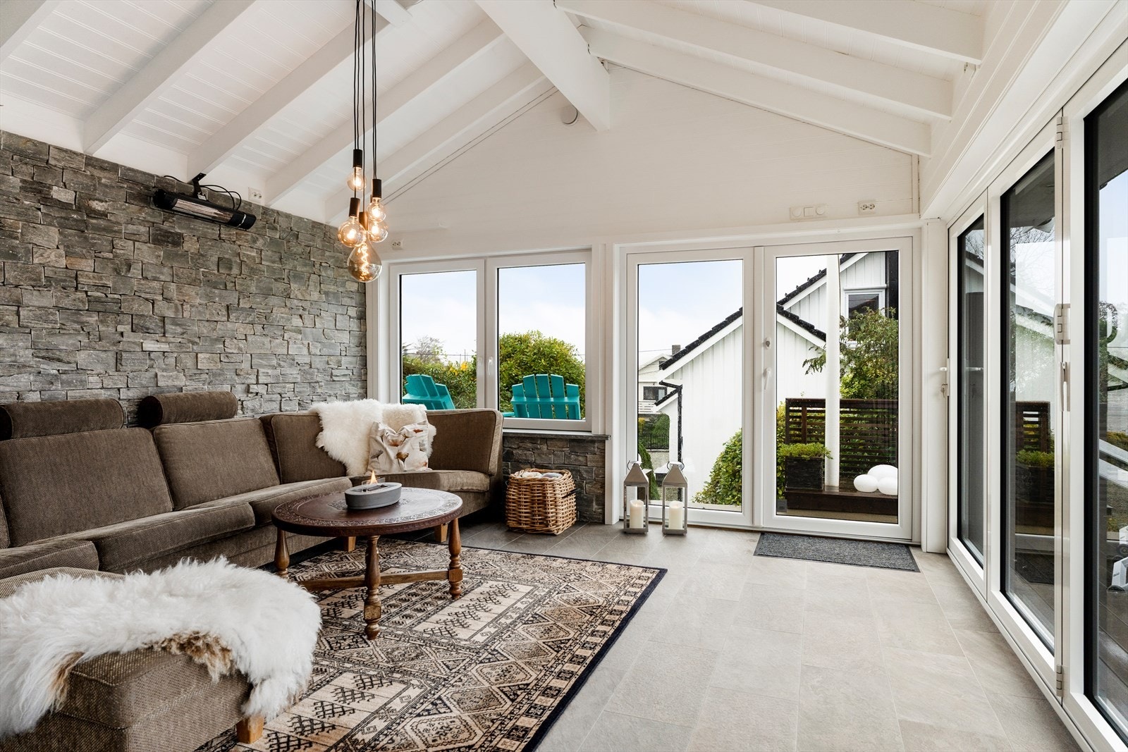 Pen hagestue med fliser på gulvoverflaten. Panel og steinpanel på veggoverflatene og store vinduer. Galleribilde