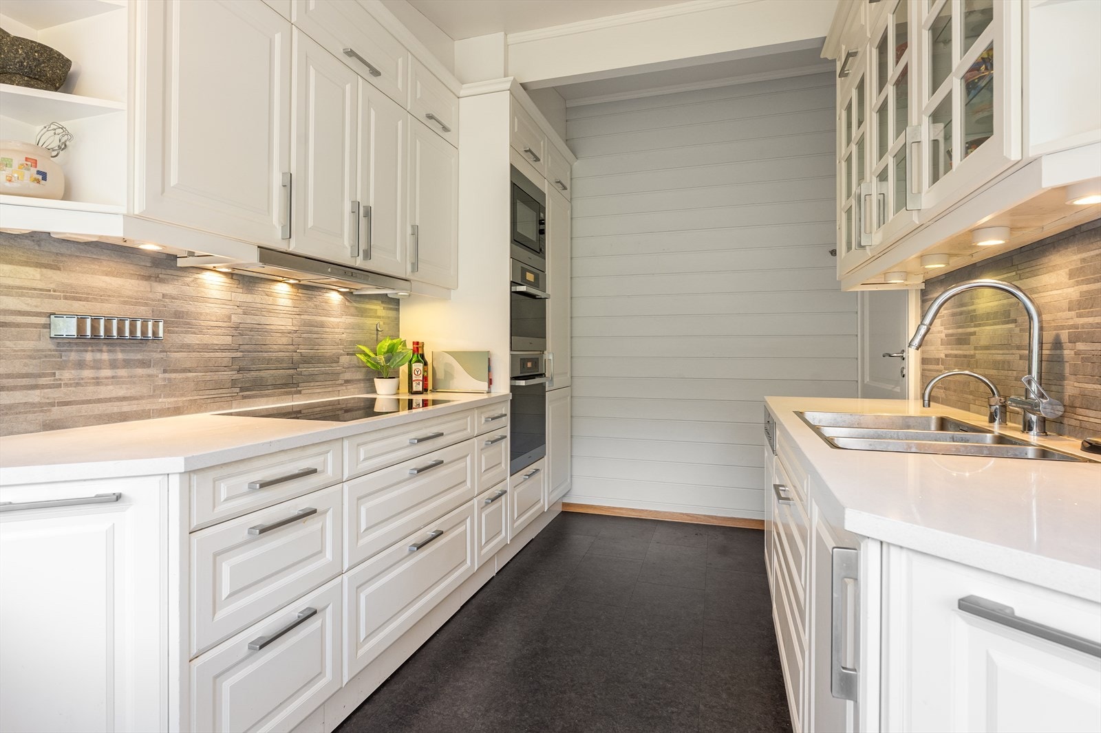 Integrert belysning i og under overskapene sikrer gode arbeidsforhold på benkeplaten som er utført i steinkompositt. Galleribilde