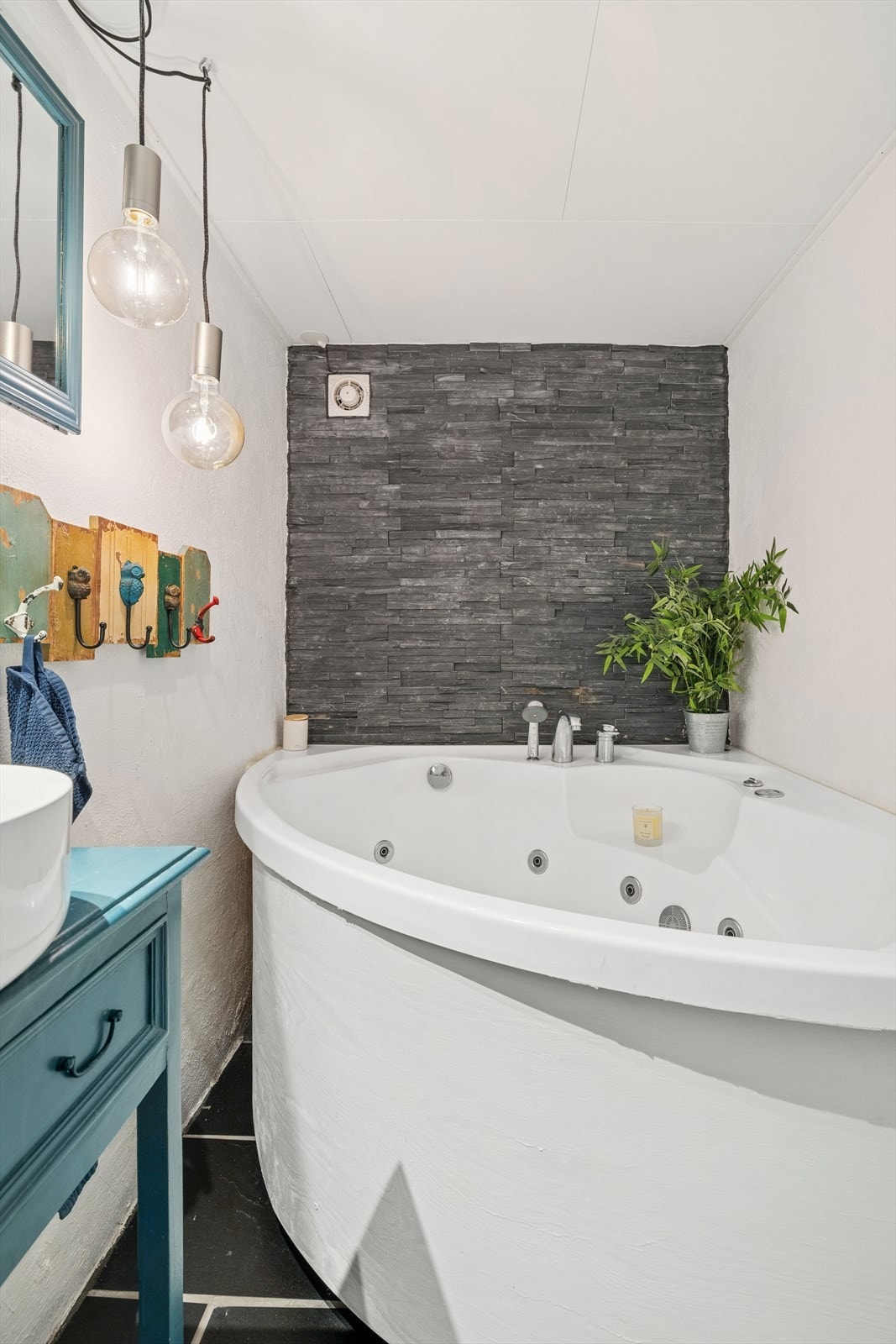 Dette badet er utstyrt med baderomsinnredning med toppmontert servant, frittstående toalett og boblebadekar. Galleribilde