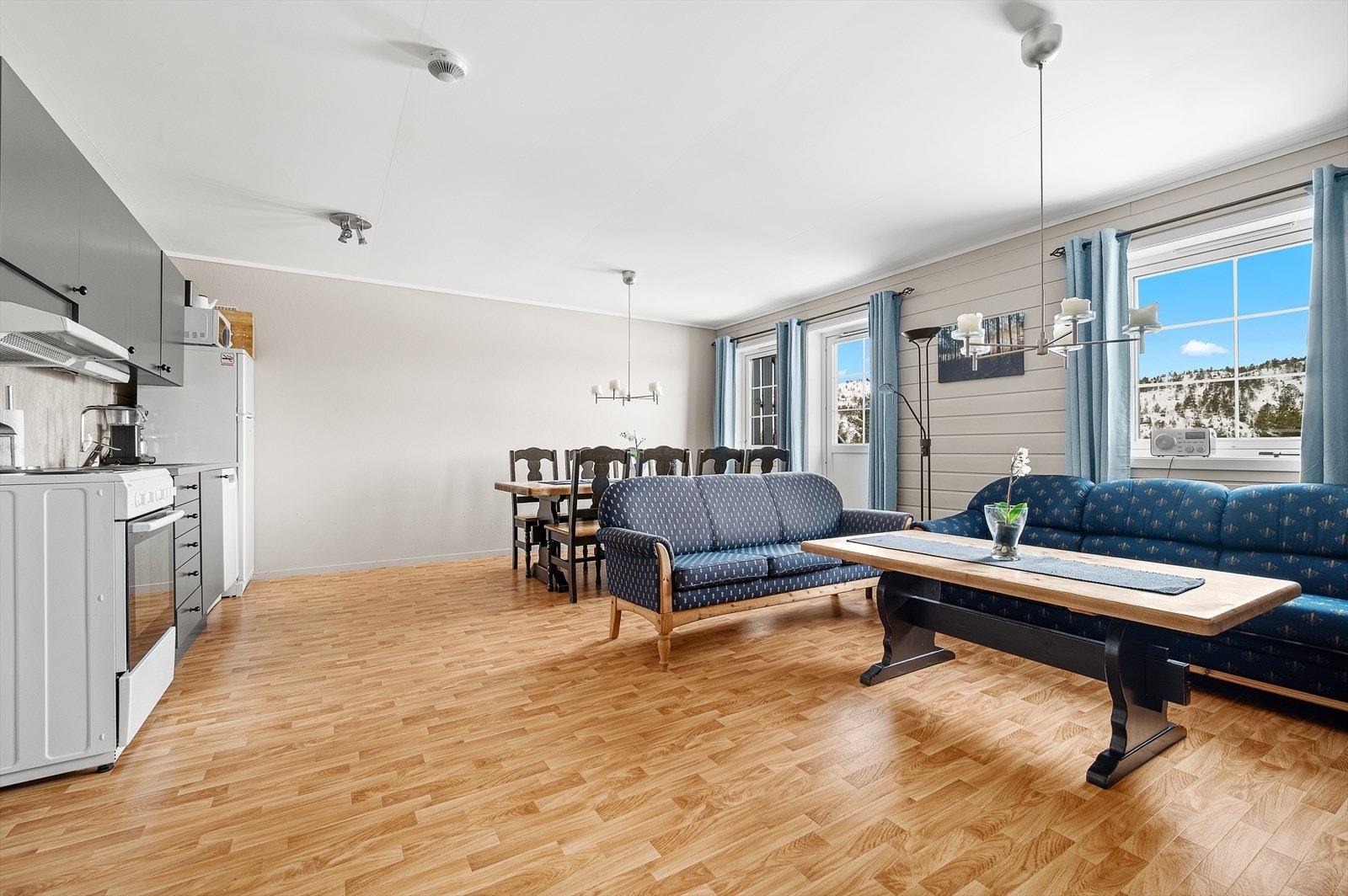 Stue/kjøkken har belegg på gulv, panelvegger og utgang til balkong. Galleribilde