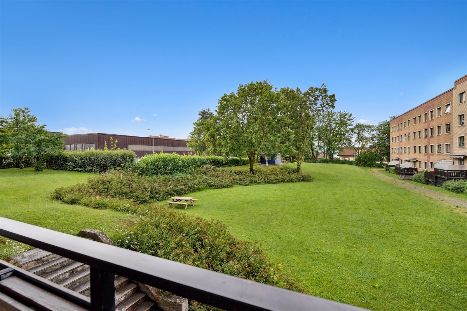 Utsikt mot fellesarealer med hyggelige uteplasser samt plass for lek og aktiviteter Galleribilde
