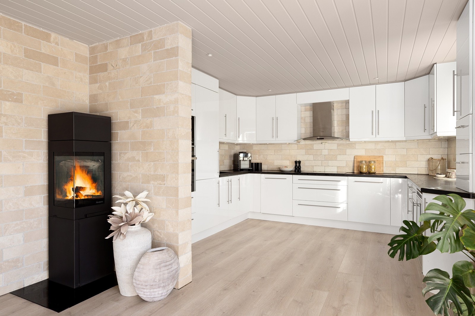 Kjøkkenet er innredet i klassisk stil med glatte fronter, benkeplate i laminat og fliser mellom over- og underskap. Galleribilde