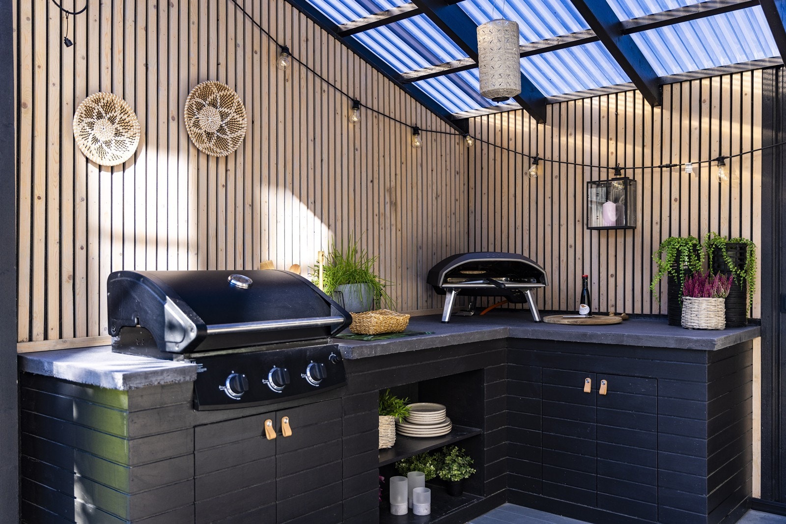 Et praktisk utekjøkken med gode arbeidsflater og plass til nedfelt grill skaper en perfekt ramme for hyggelige måltider og sosiale sammenkomster utendørs. Galleribilde