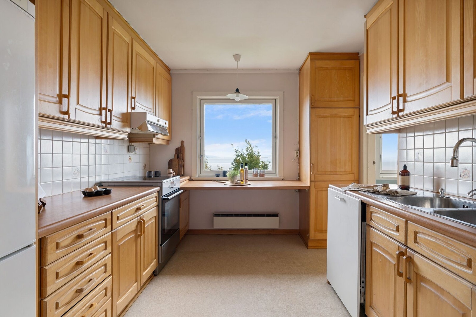 Innholdsrikt og klassisk kjøkkeninnredning med profilerte fronter. Kjøkkenet byr på med rikelig av skap- og skuffeplass til oppbevaring. Galleribilde