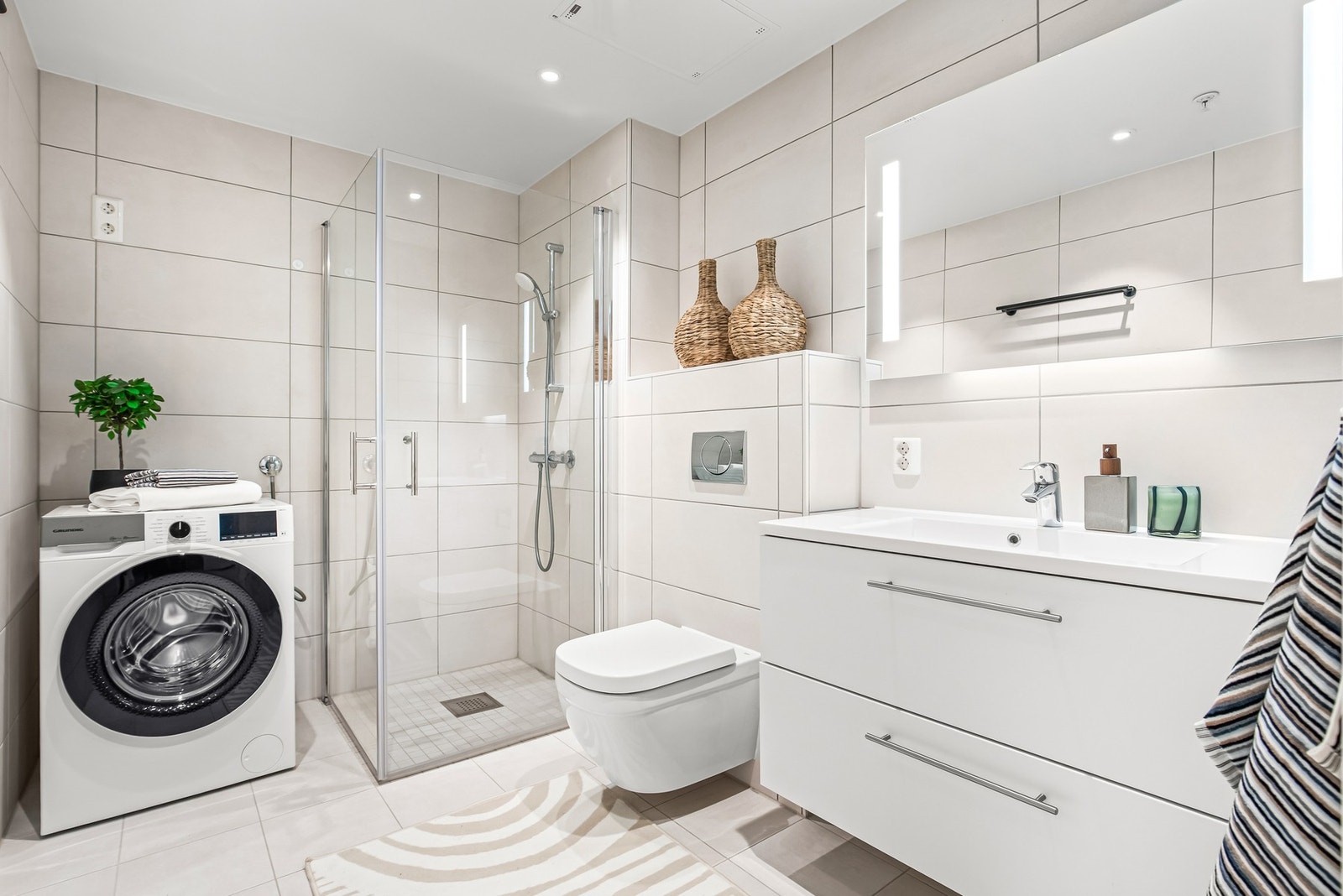 Delikat baderom med gulvvarme og opplegg for vaskemaskin Galleribilde