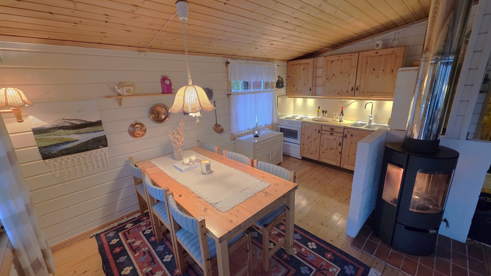 Selgers bilde av spisestue og kjøkken. Her er det vedovn etablert. Galleribilde