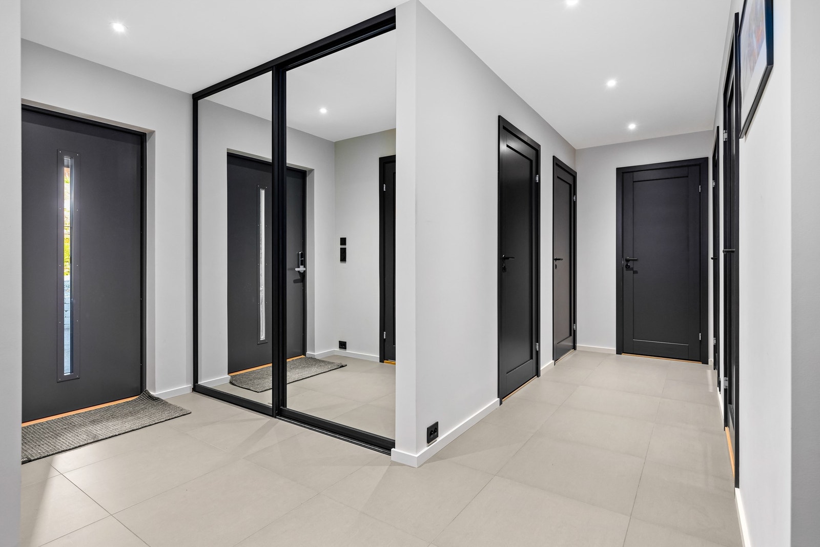 Fin gang med store fliser, varme i gulv og integrert garderobeskap med skyvedører. Galleribilde