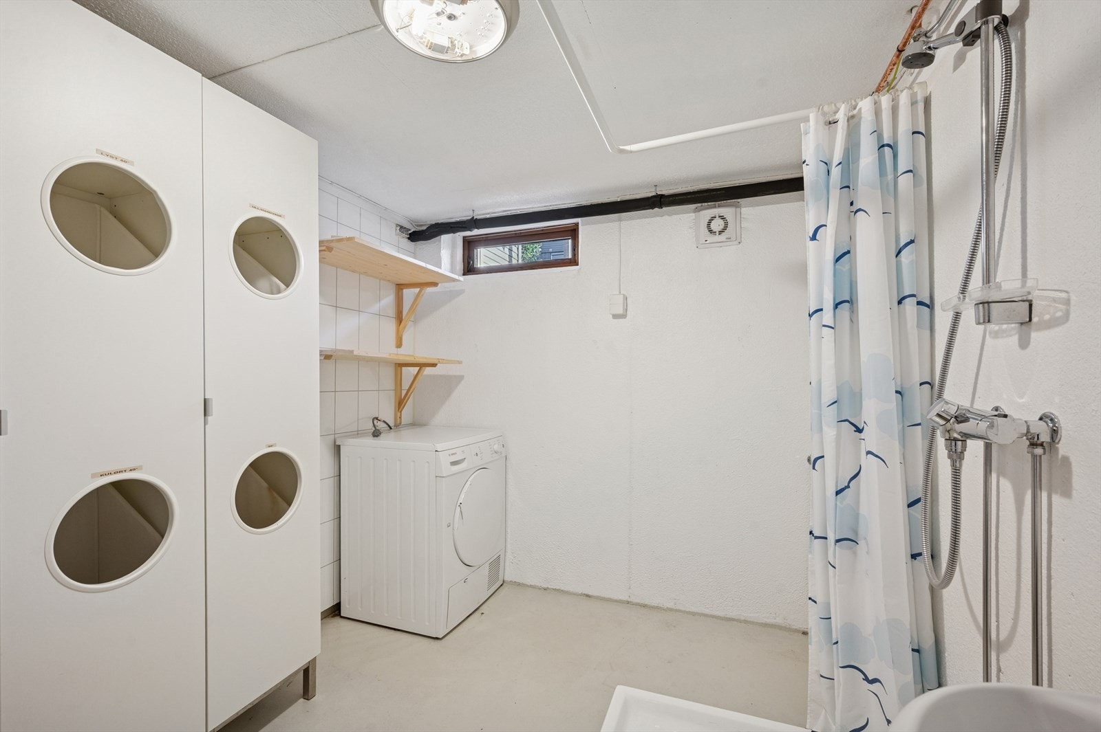 Praktisk vaskerom med dusjløsning, toalett og opplegg for vaskemaskin. Galleribilde