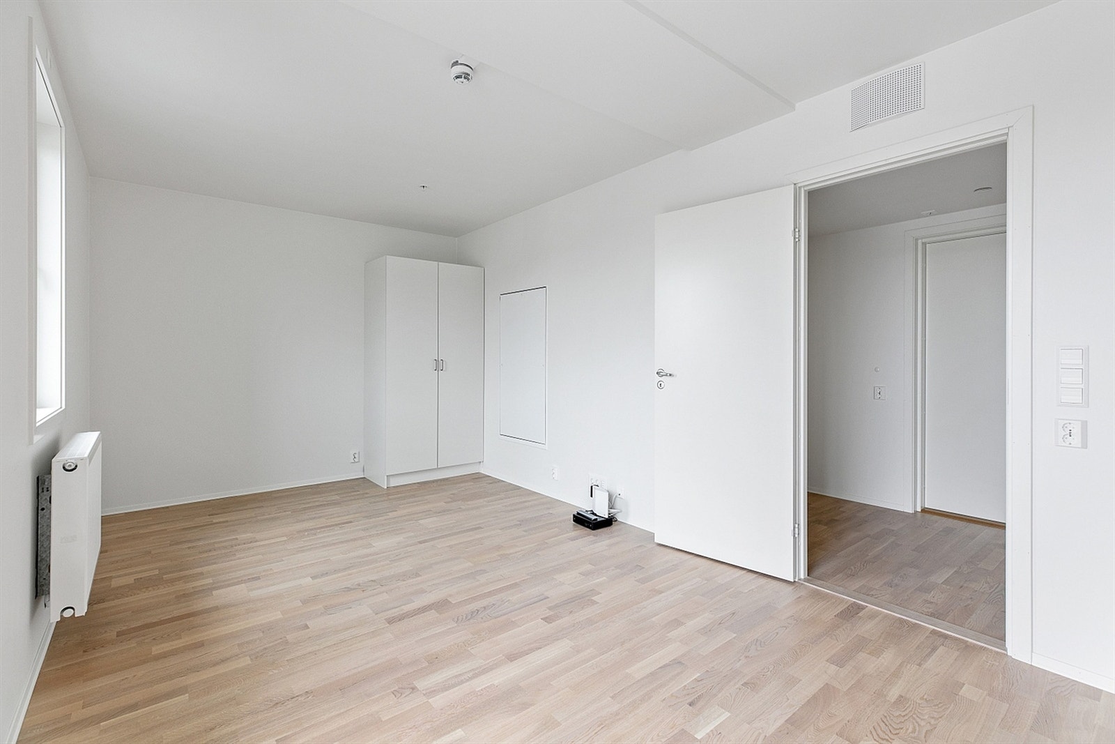 Lys og moderne stueløsning med godt med naturlig lysinnslipp. Rommet inkluderer et praktisk garderobeskap som gir god oppbevaringsplass. Galleribilde