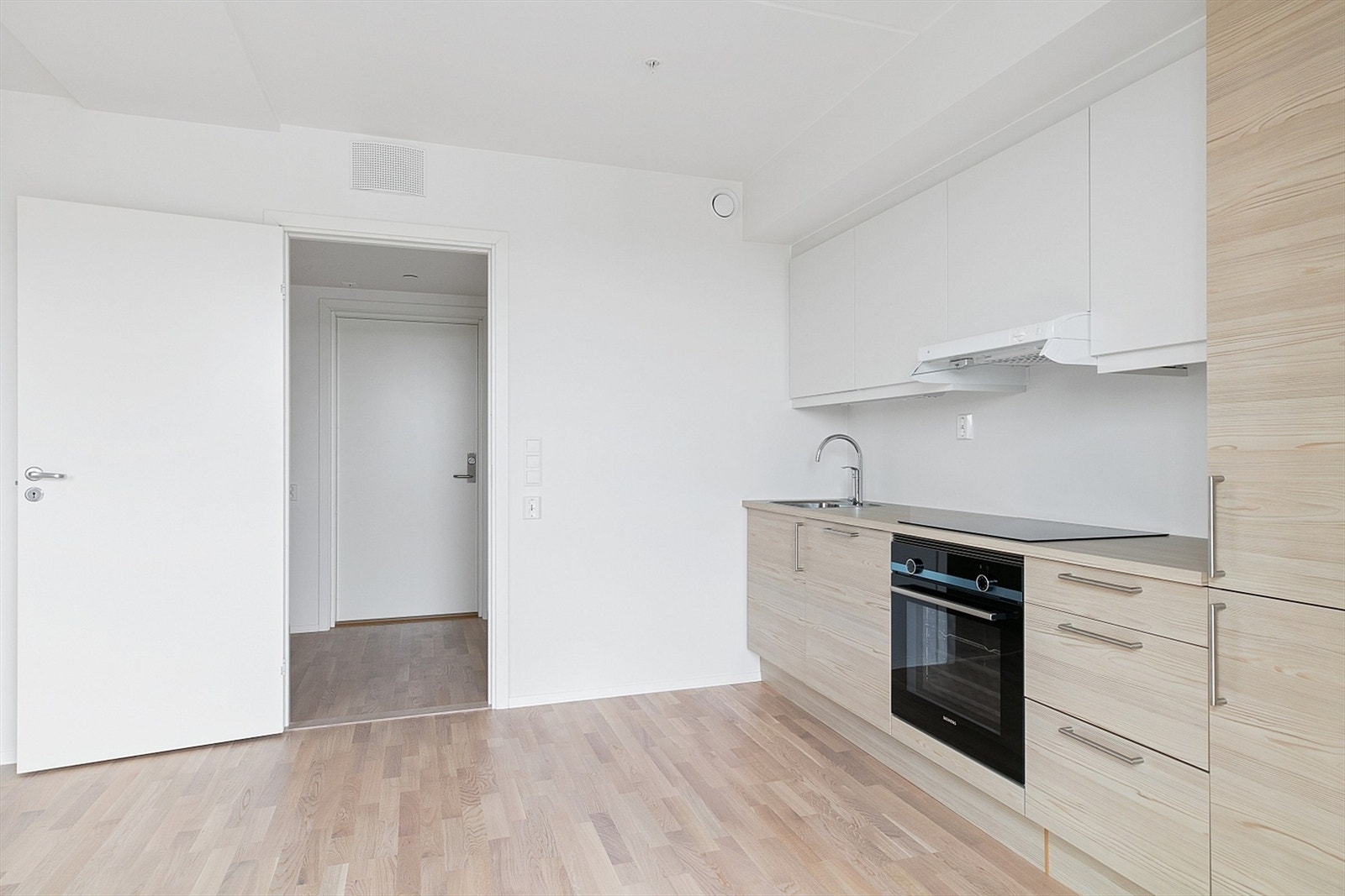 Fra entreen kommer du inn i en lys og åpen kjøkken- og stueløsning, som skaper et romslig og trivelig oppholdsrom. Galleribilde