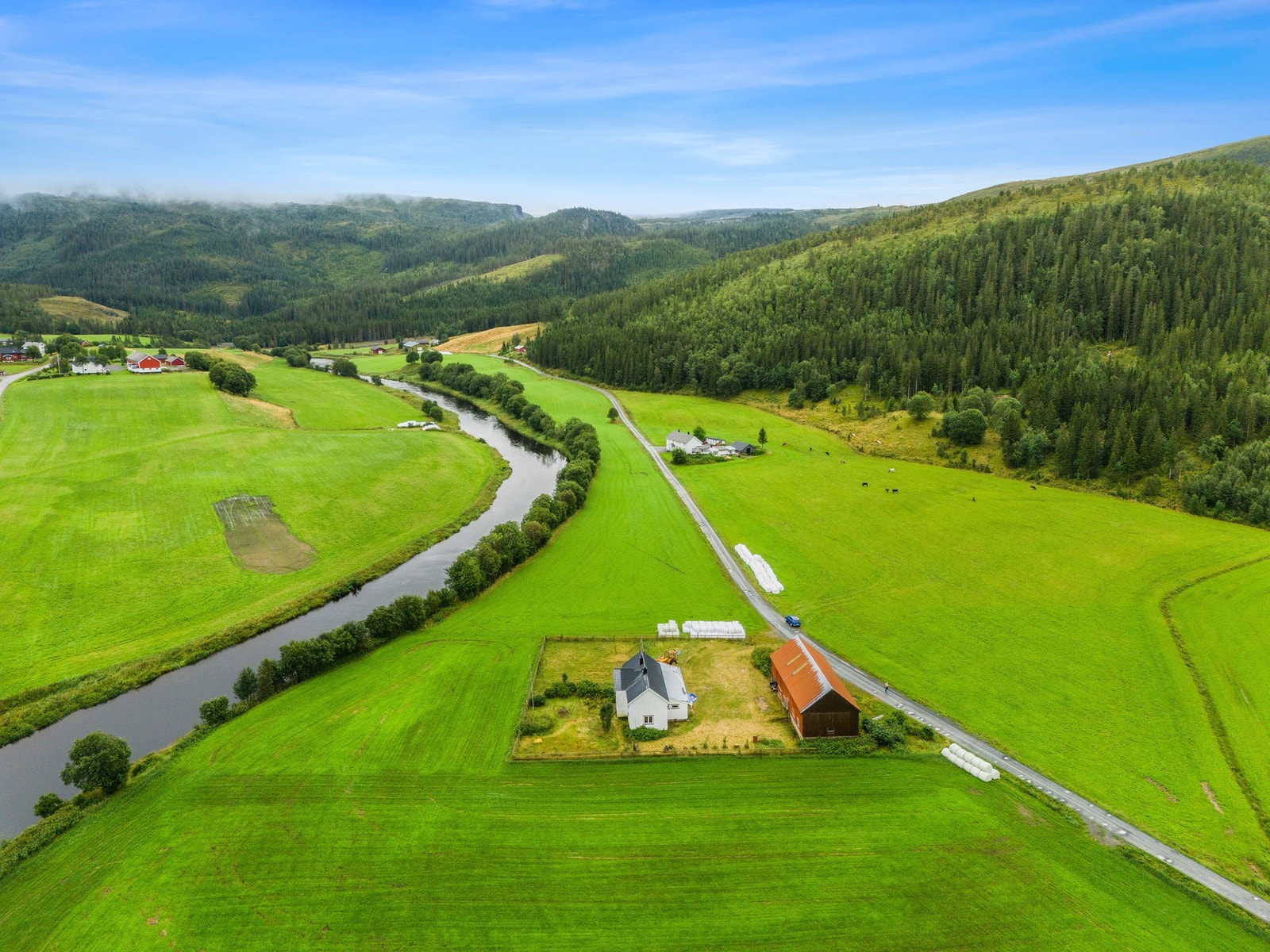 Eiendommen ligger usjenert til i naturskjønne omgivelser omkranset av fjell og grønne sletter Galleribilde