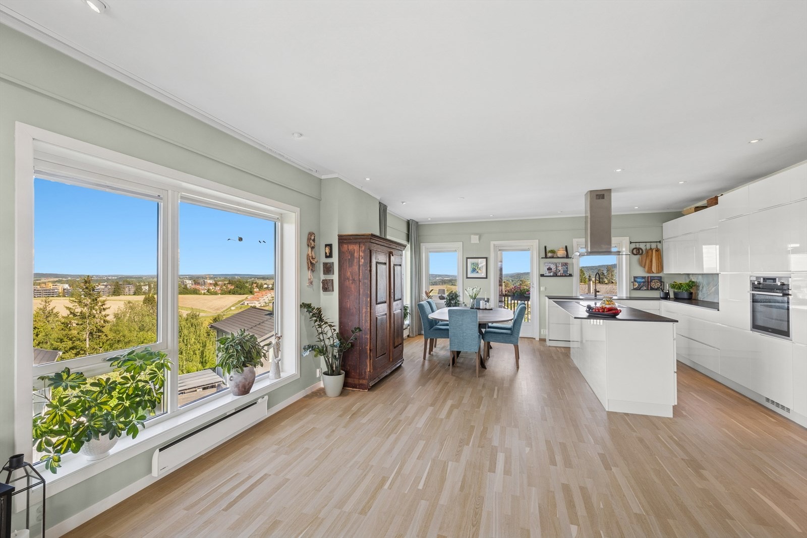 Åpen løsning mellom stue og kjøkken og store vindusflater Galleribilde