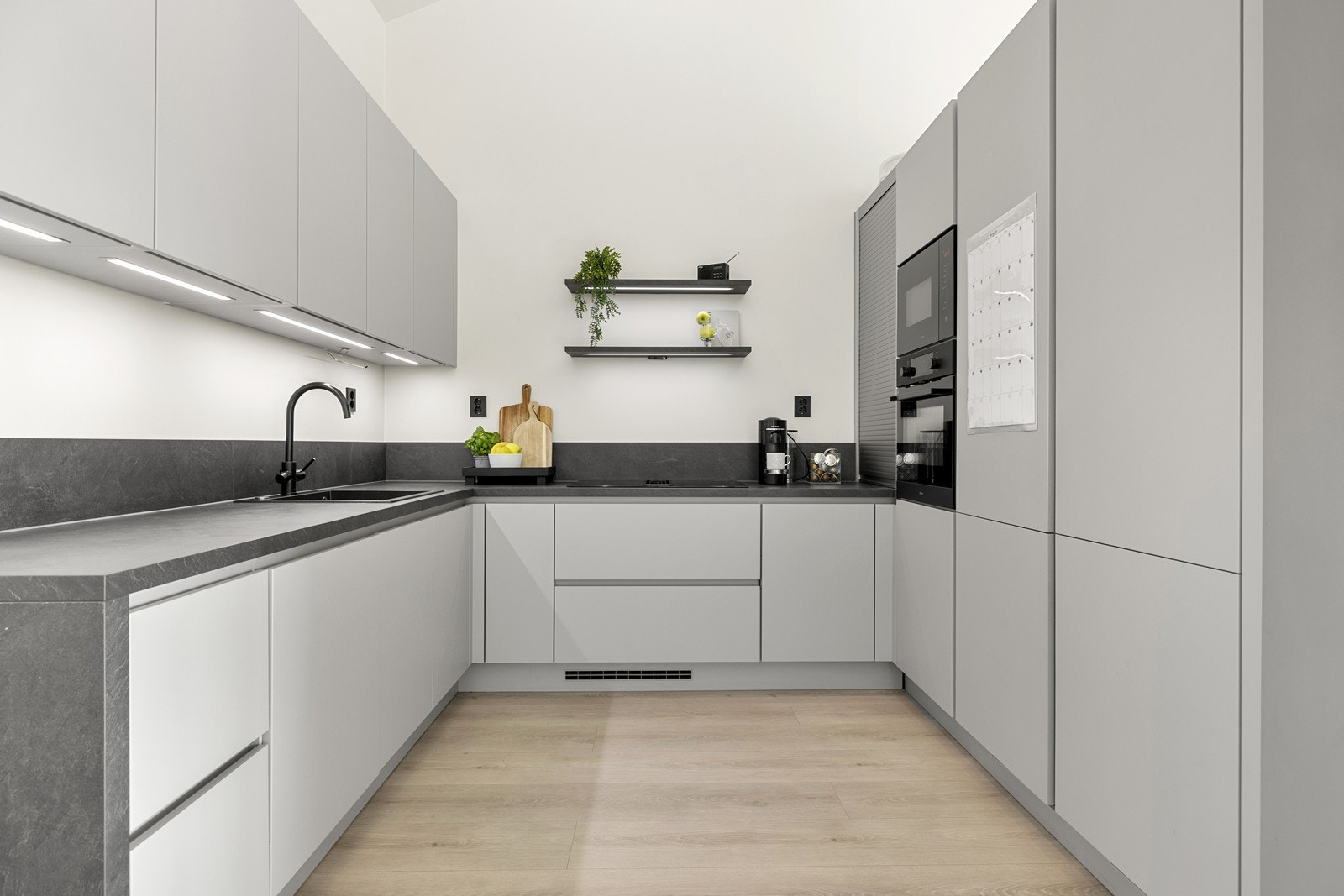 Kjøkkeninnredningen består av skap med glatte, lyse fronter og benkeplate i laminat. Galleribilde