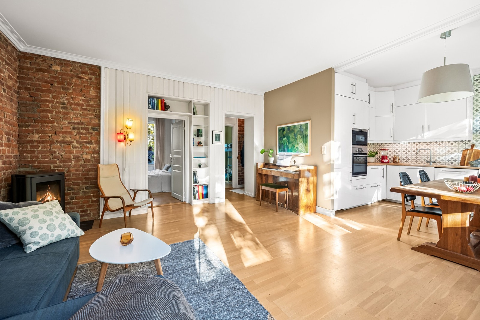 Leiligheten har en stor og luftig stue med ildsted og store vindusflater. Galleribilde