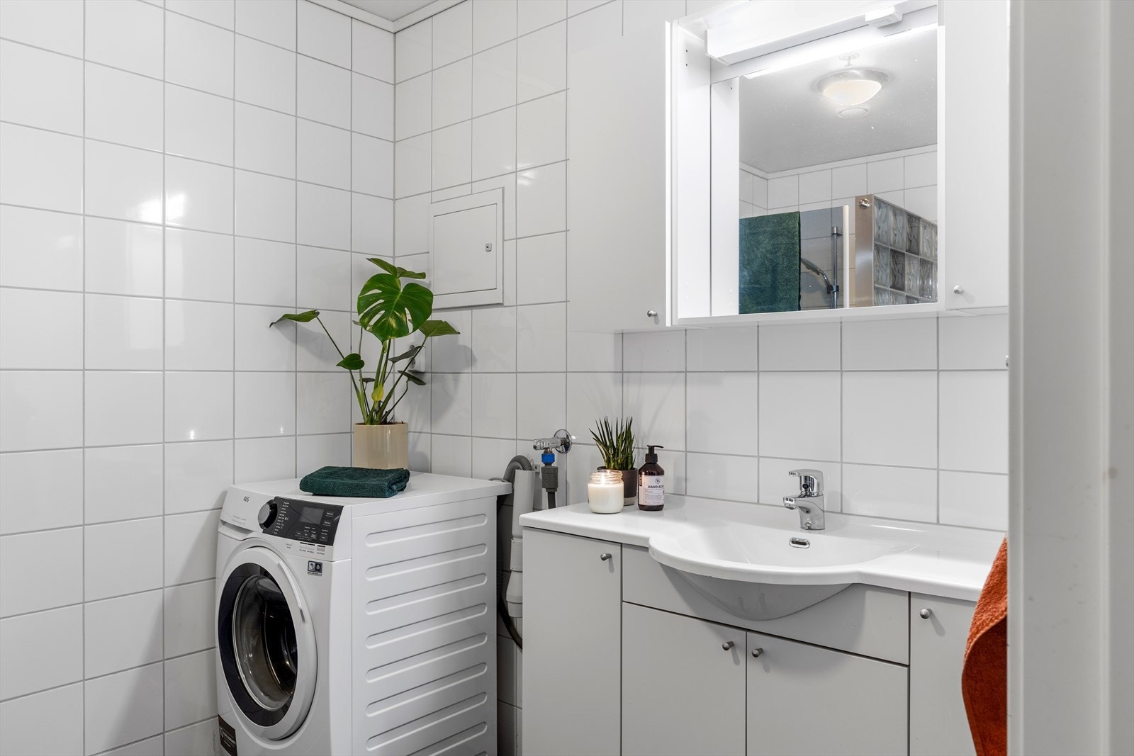 Innredningen består av stort dusjhjørne, vegghengt wc, opplegg for vaskemaskin og servant med underskap. Galleribilde