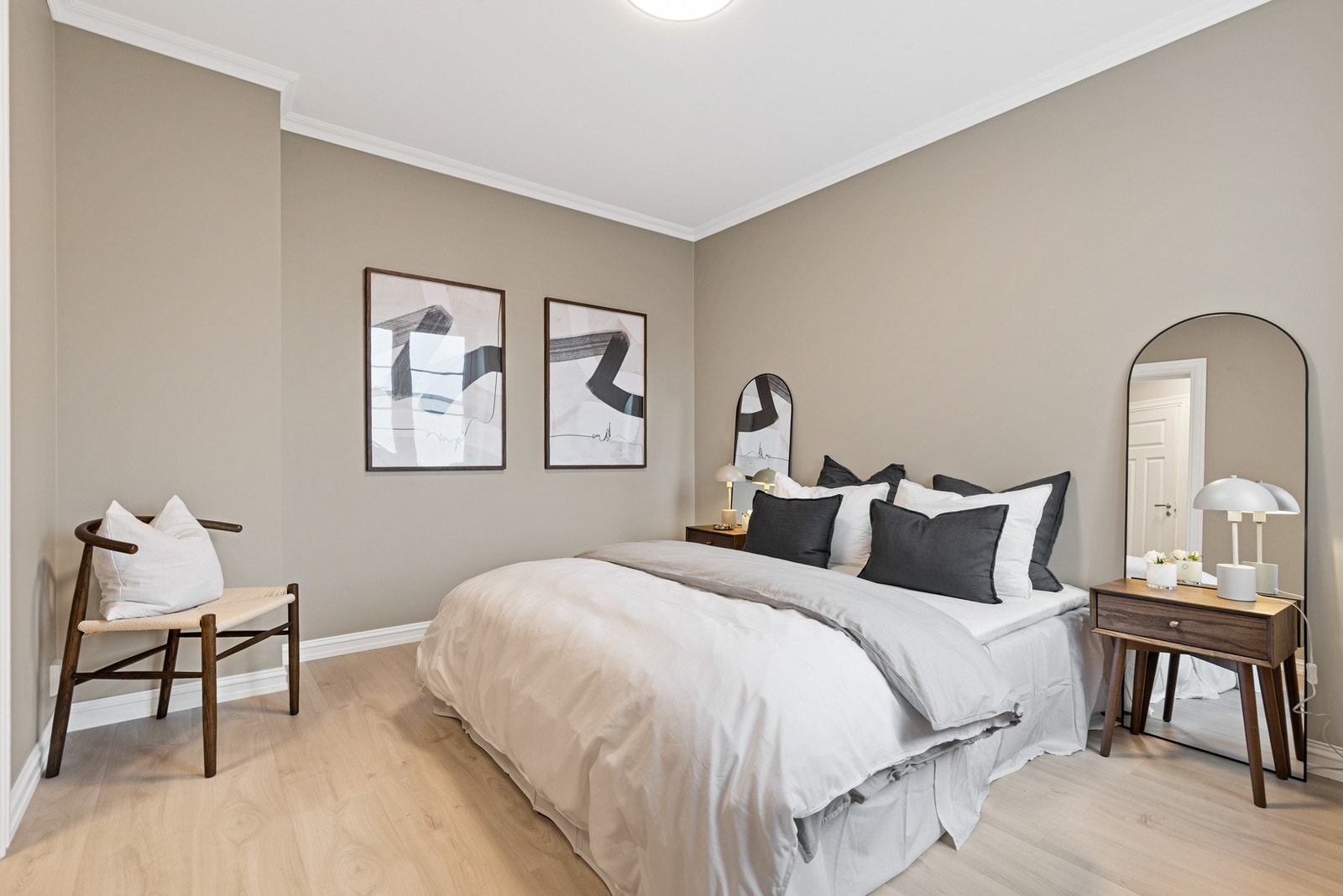 Romslig soverom med 1-stavs laminat på gulv og slette vegger malt i en behagelig beige tone Galleribilde