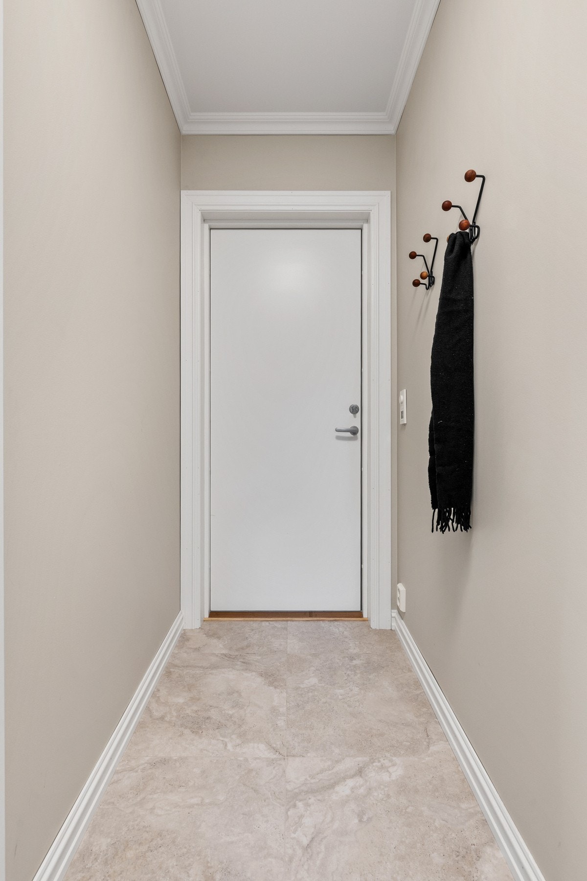 Pen entré med flislagt gulv og vegghengt knagg for oppheng av yttertøy Galleribilde